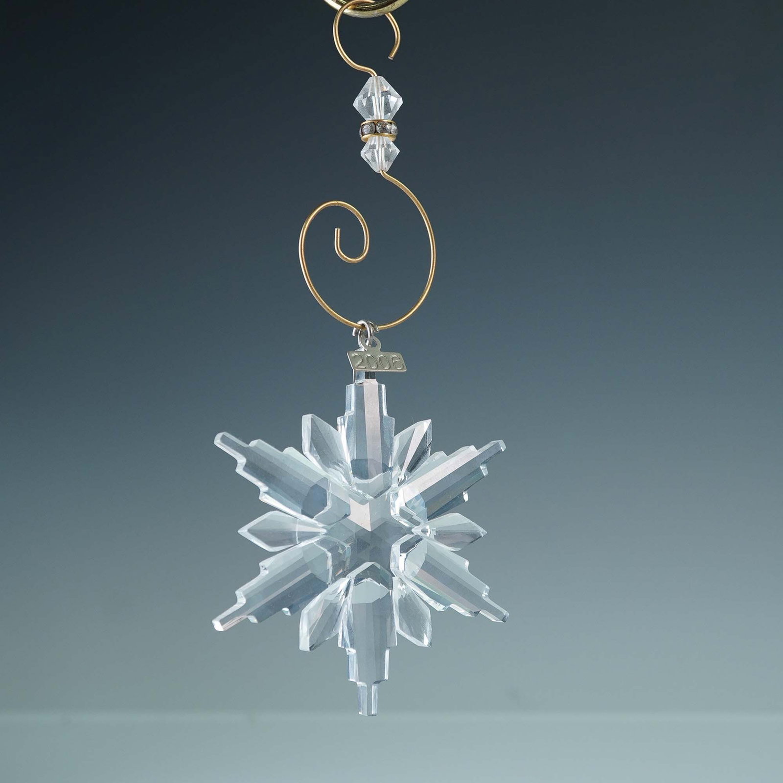 Swarovski 2006 Christmas Snowflake Ornament with Enhancer and Box: Swarovski crystal Christmas snowflake ornament dated 2006, marked with the Swarovski swan. This multifaceted clear crystal ornament features the signature annual snowflake design and includes its orig