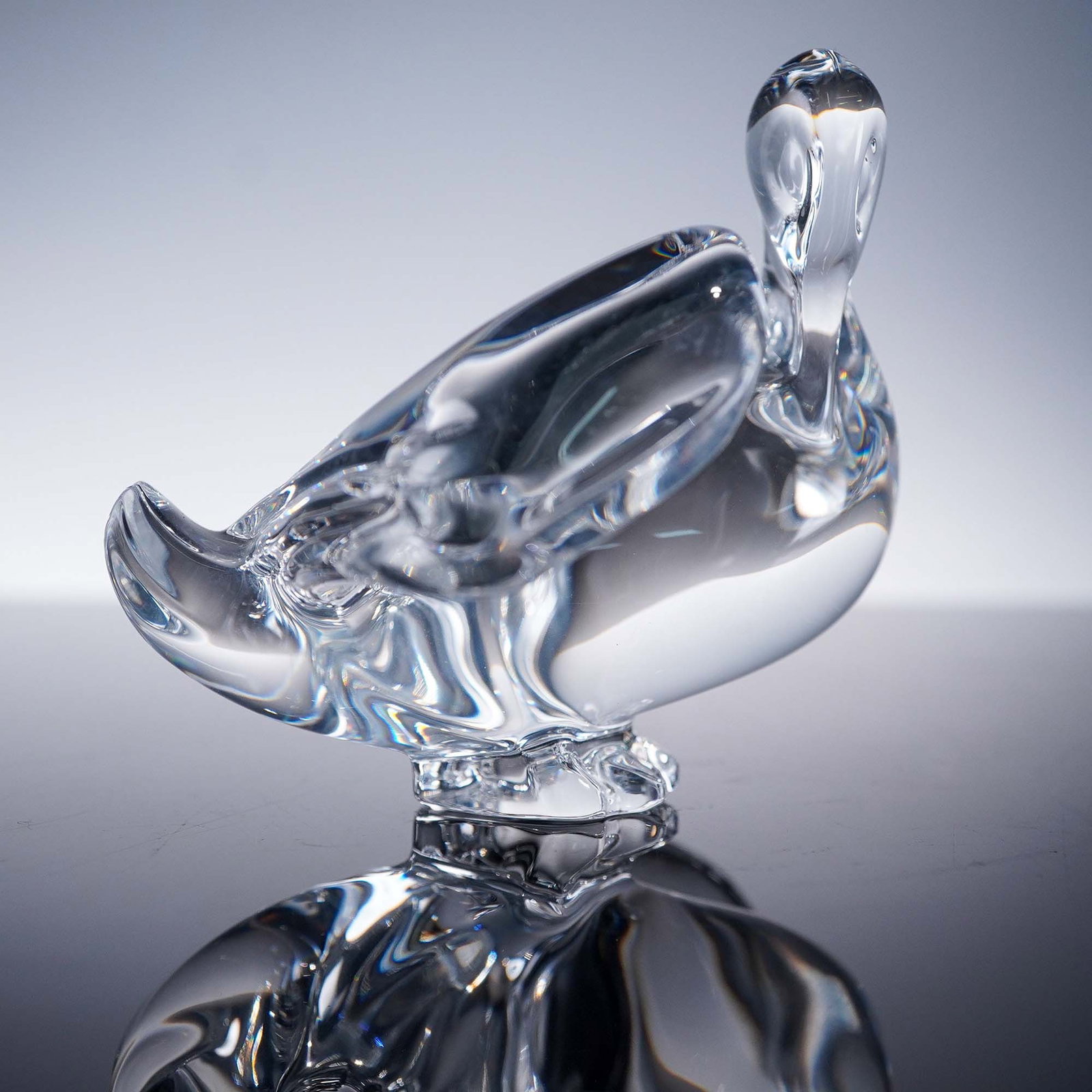 Baccarat Clear Crystal Figurine, Duck: This charming Baccarat clear crystal figurine captures the fluid, organic form of a duck, showcasing the masterful craftsmanship for which the renowned French crystal house is known. The piece feature