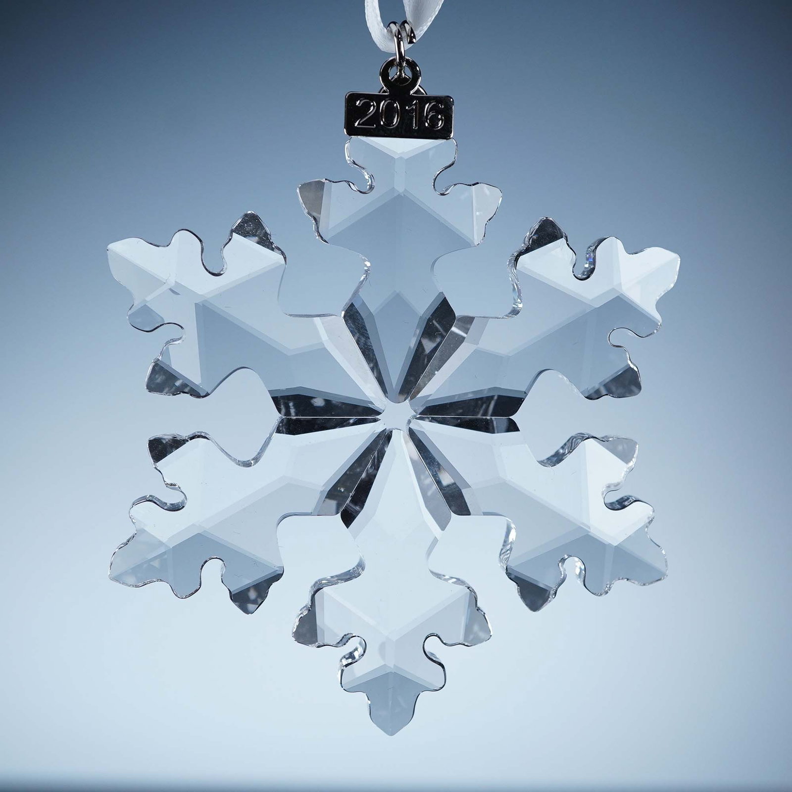 Swarovski Crystal Ornament, 2016 Annual Christmas: This retired Swarovski 2016 Annual Edition Christmas Ornament features a radiant 6-point faceted clear crystal snowflake with gently contoured edges and a 2016-etched metal tag. It hangs from a white 