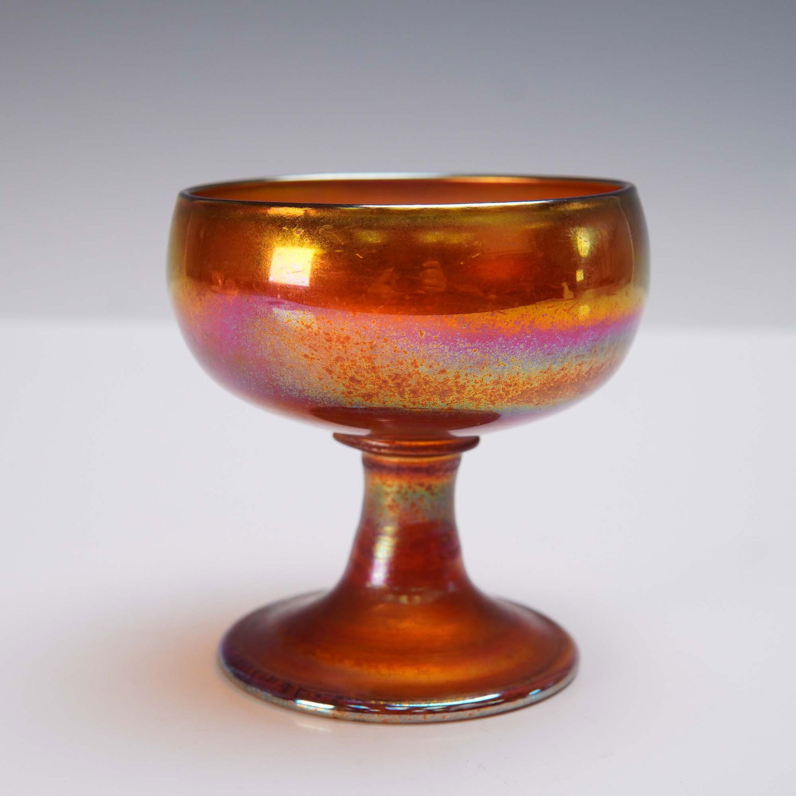 Tiffany Favrile Iridescent Gold Art Glass Footed Sherbet: Antique Tiffany Studios Favrile iridescent art glass footed sherbet cup in a radiant gold hue, showcasing the signature luster and delicate striations of Louis Comfort Tiffany's early 20th-century cra