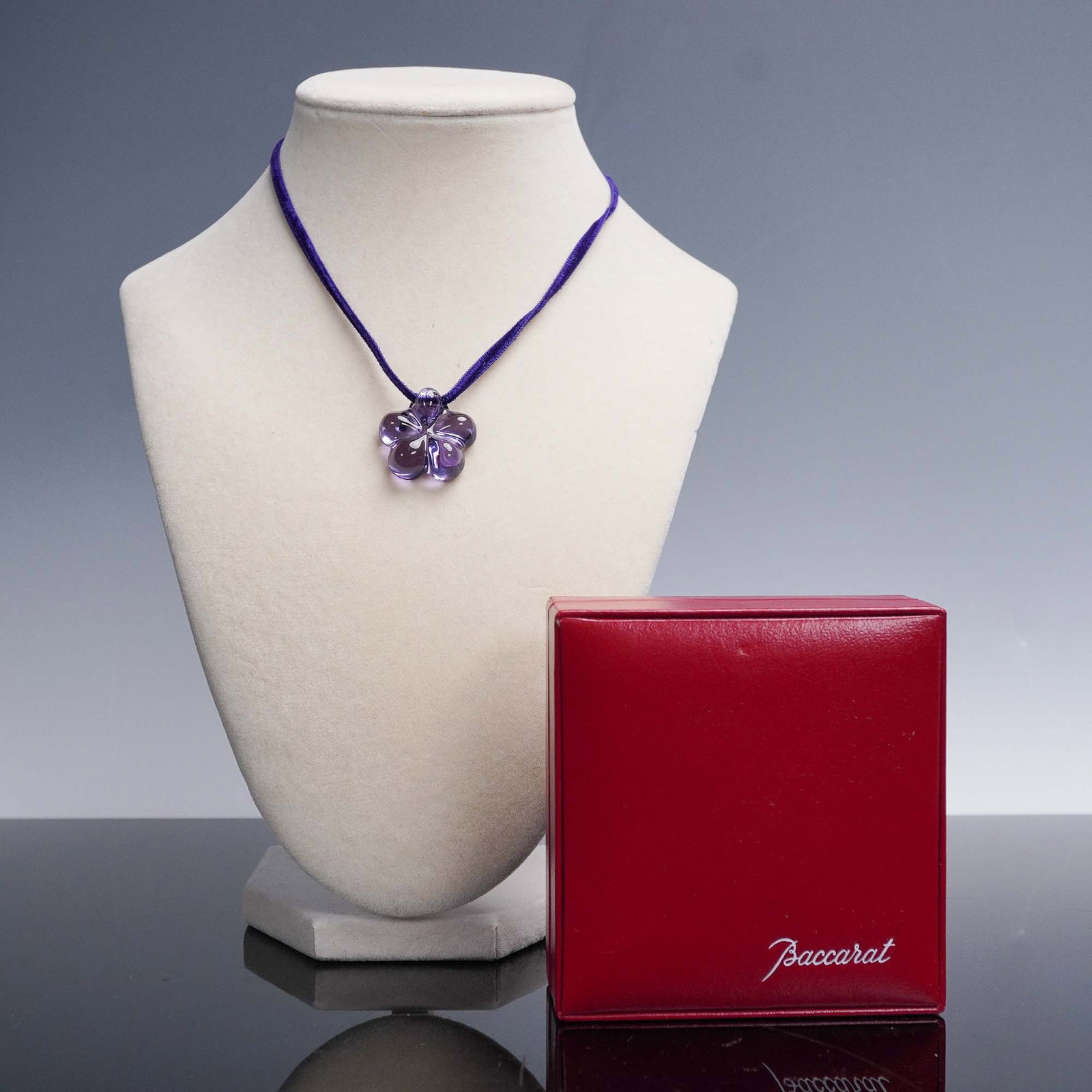 Baccarat Violet Crystal Lili Flower Choker: Elegant Baccarat violet crystal flower chocker with the pendant suspended on a rich purple cord. The floral design features sculptural petals in finely crafted crystal with a soft sheen and high clari