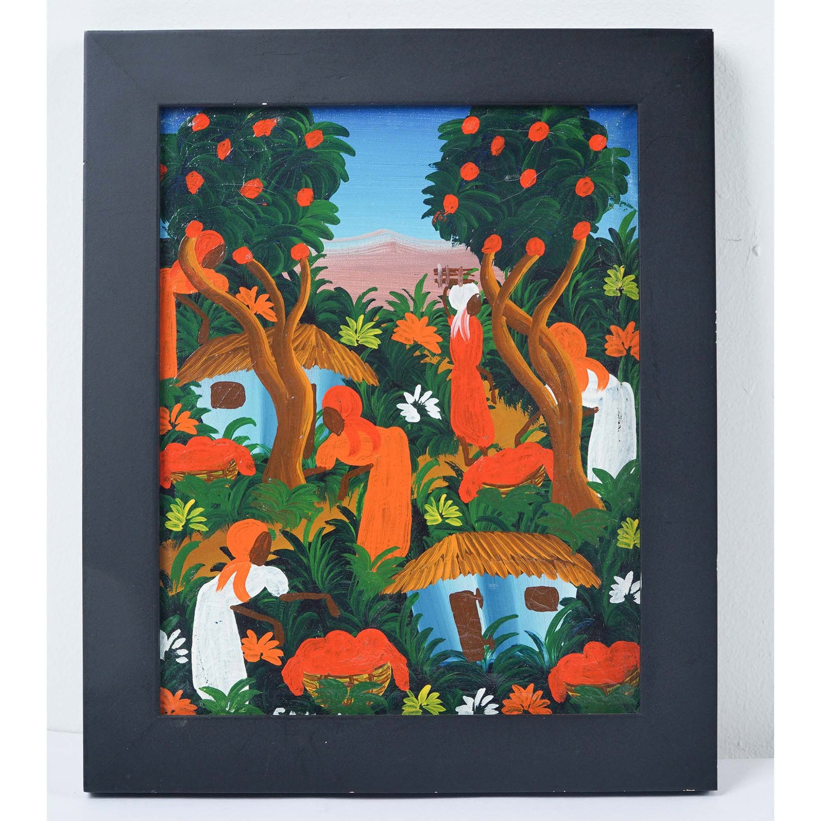 Roosevelt Sanon, Haitian Oil on Canvas, Picking Fruit, Signed: A vibrant folk art painting on canvas depicting a lively Haitian village market scene with women in orange and white garments picking fruit and gathering water amid lush foliage. The stylized trees ar