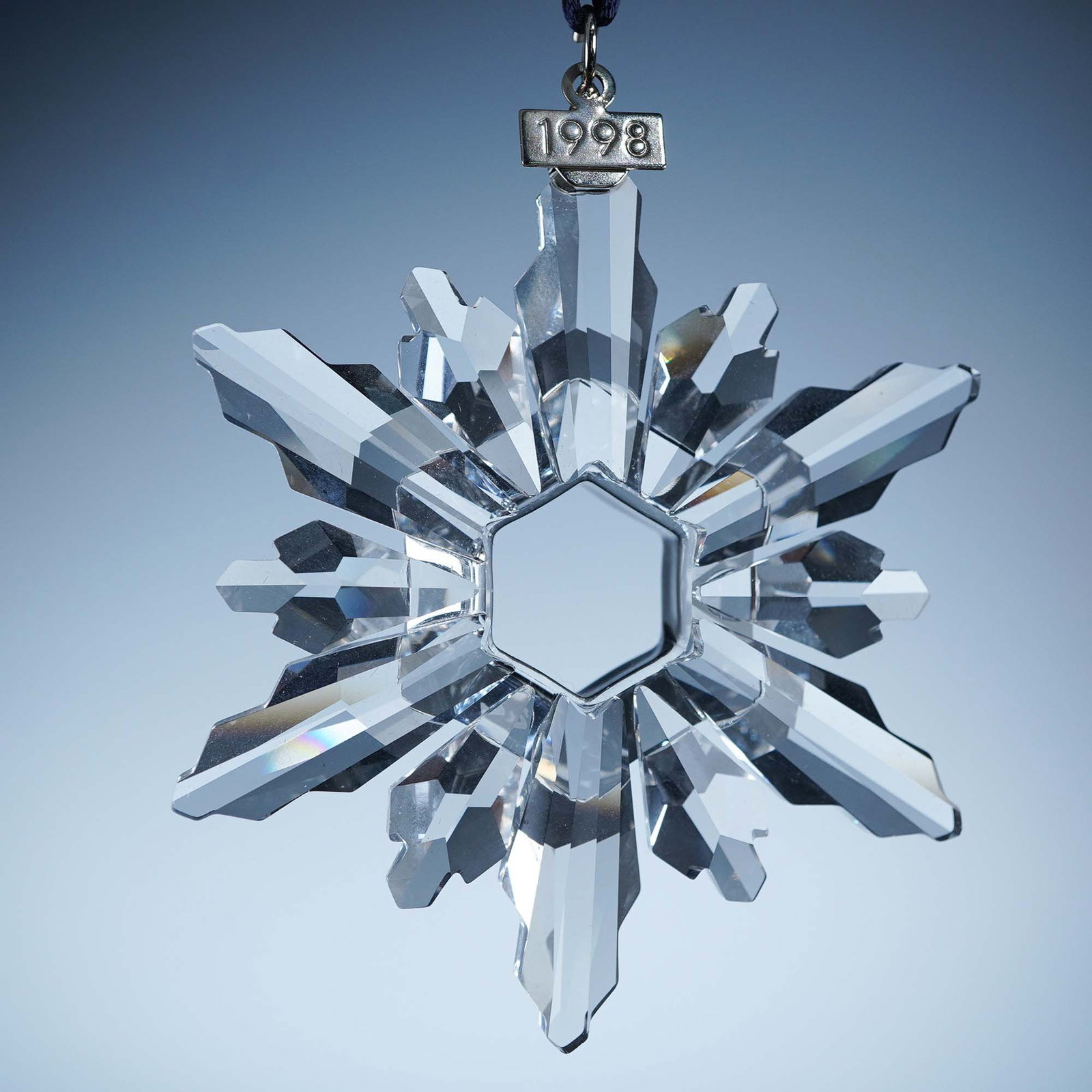 Swarovski Crystal Ornament, 1998 Christmas: This retired Swarovski 1998 Annual Edition Christmas Ornament, features a brilliant 12 point star with alternating long and short crystal rays arranged around a faceted hexagonal center. The ornament 