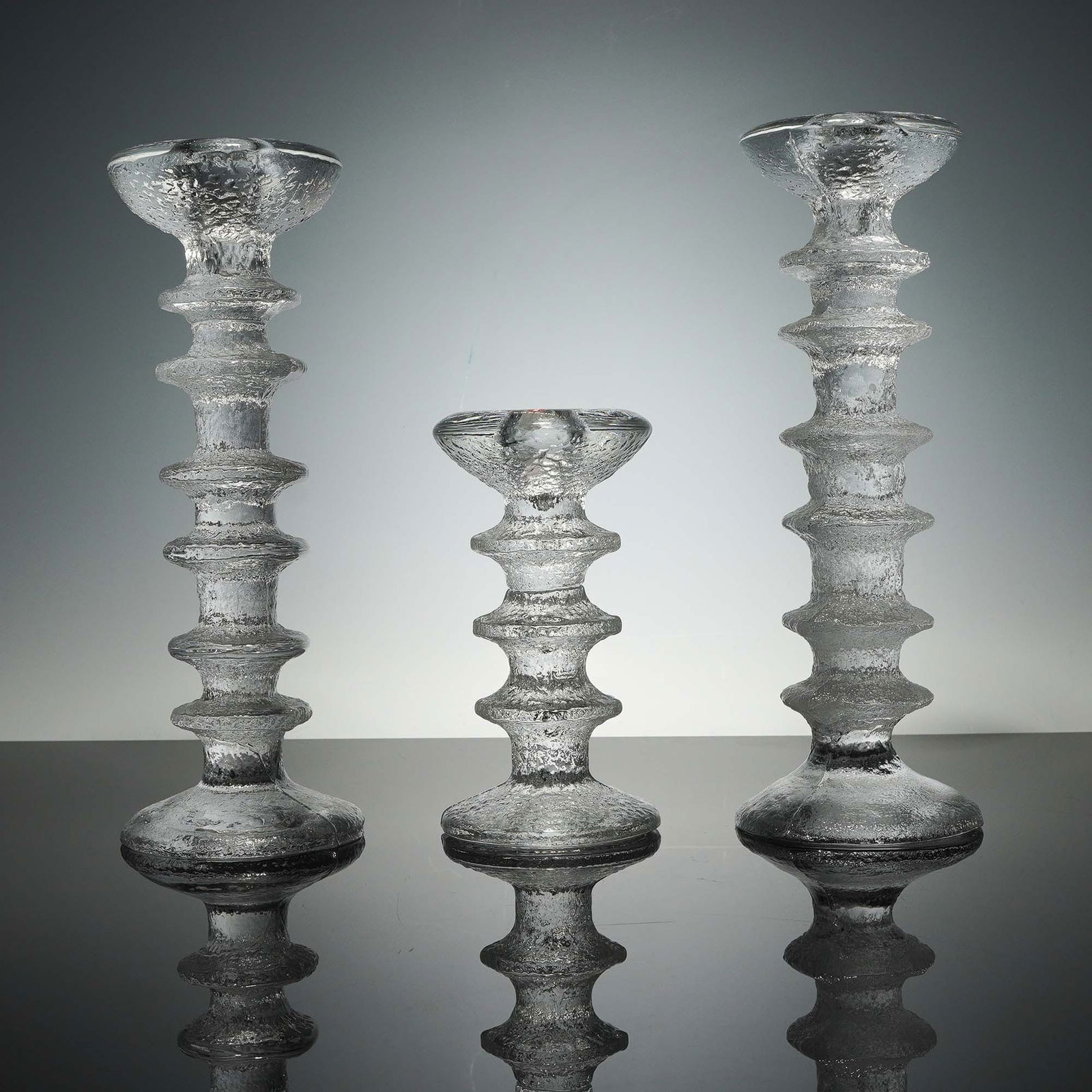 3pc Iittala Festivo Crystal Candleholders: Set of three vintage Iittala Festivo crystal candleholders, designed by Timo Sarpaneva for the renowned Finnish glassmaker Iittala. These iconic mid-century pieces feature a distinctive ice-textured s
