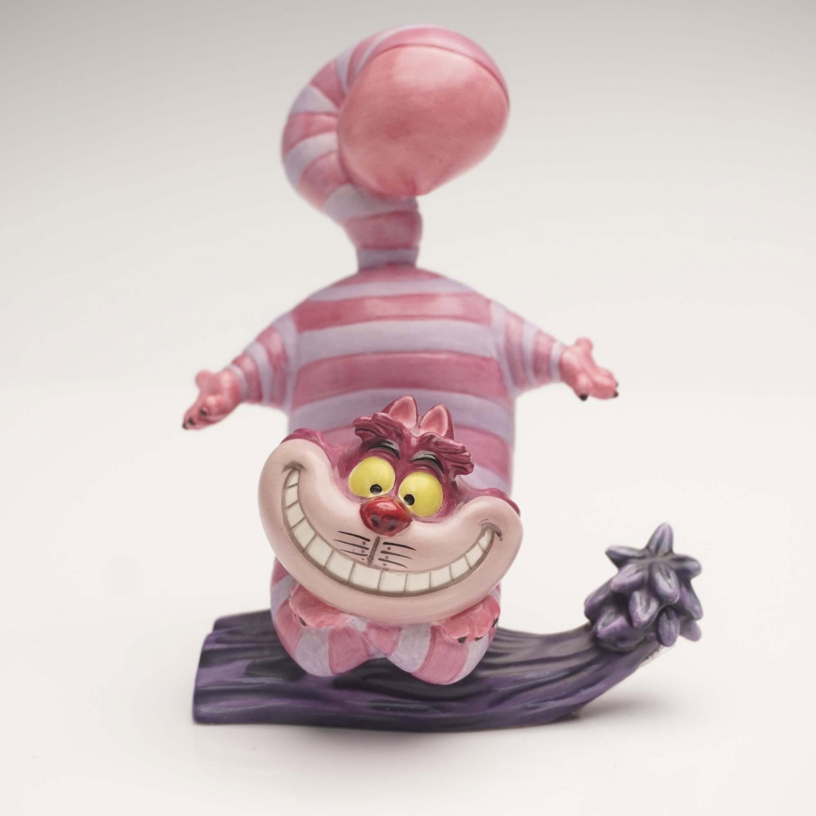 WDCC Figurine, Cheshire Cat "Twas Brillig?" Alice in Wonderland: This vibrant porcelain figurine from the Walt Disney Classics Collection features the delightfully elusive Cheshire Cat from Alice in Wonderland, perched on a curving tree branch with his iconic strip