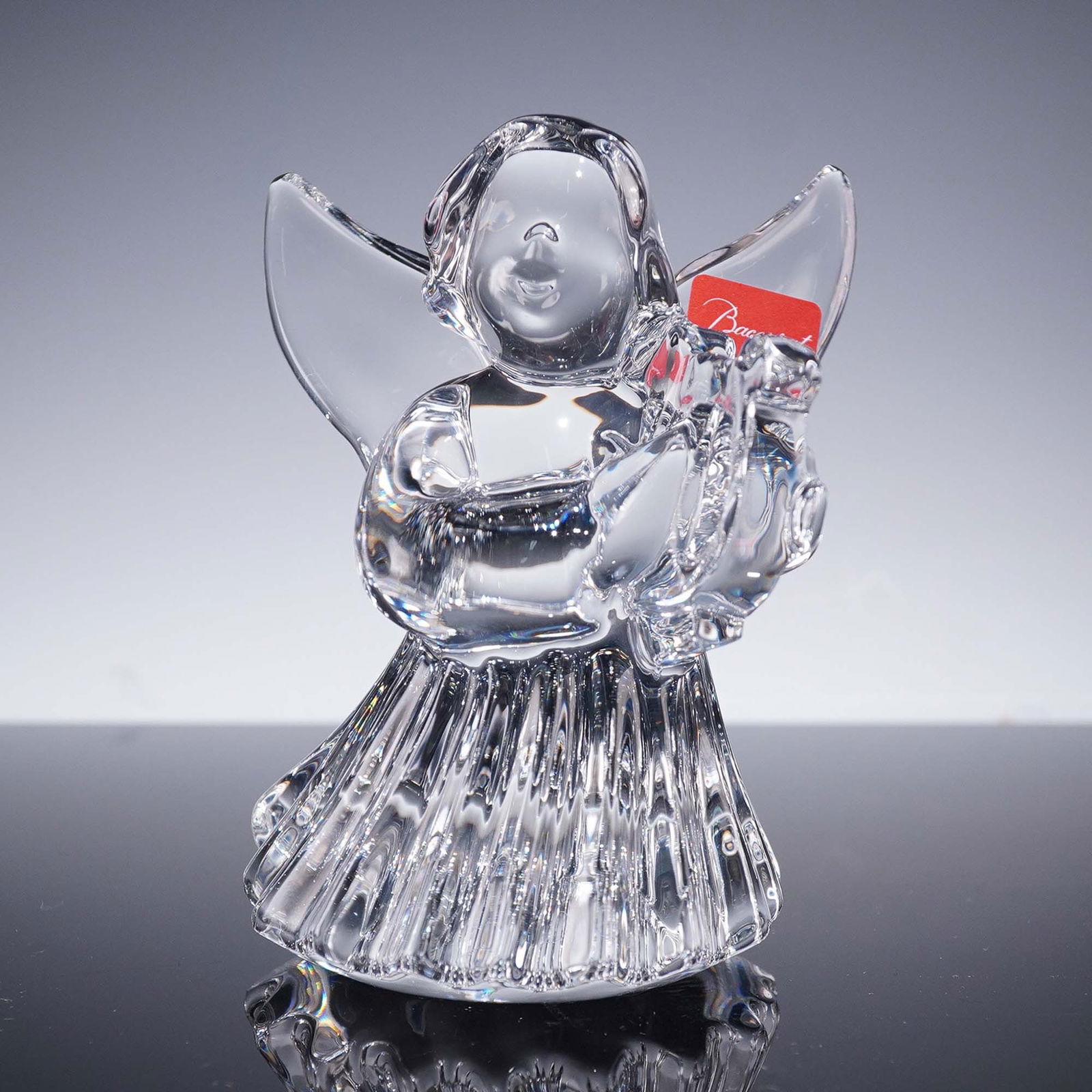 Baccarat Crystal Figurine, Angel with Harp: Graceful Baccarat crystal figurine featuring an angel in a flowing gown, gently playing a harp. This hand-crafted piece showcases Baccarat's renowned clarity and attention to detail, evident in the de