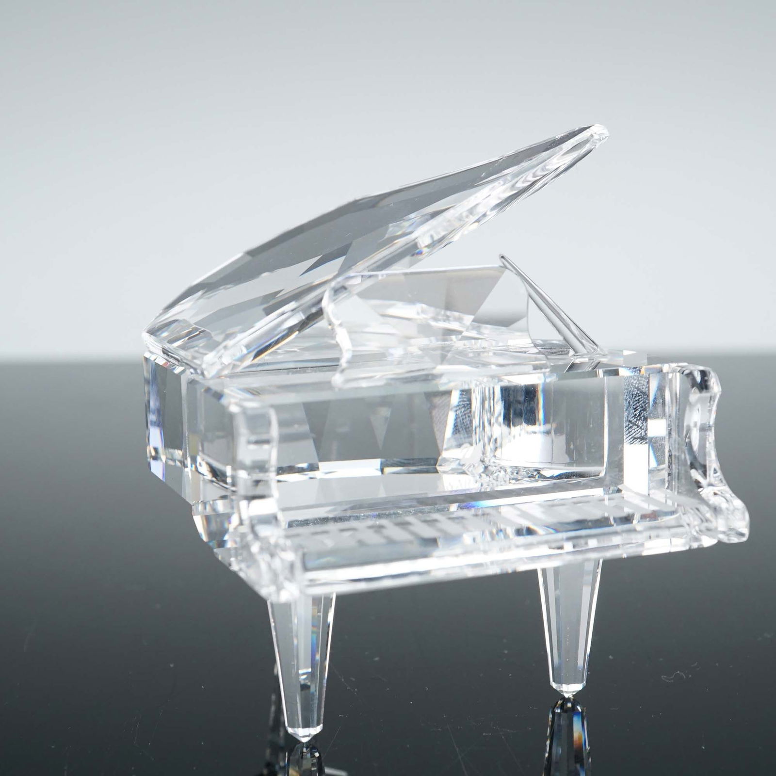 Swarovski Crystal Figurine, Grand Piano: Elegant Swarovski crystal figurine titled Grand Piano, designed by Martin Zendron. Introduced in 1993 and retired in 2008, this finely faceted clear crystal piece captures the graceful form of a grand