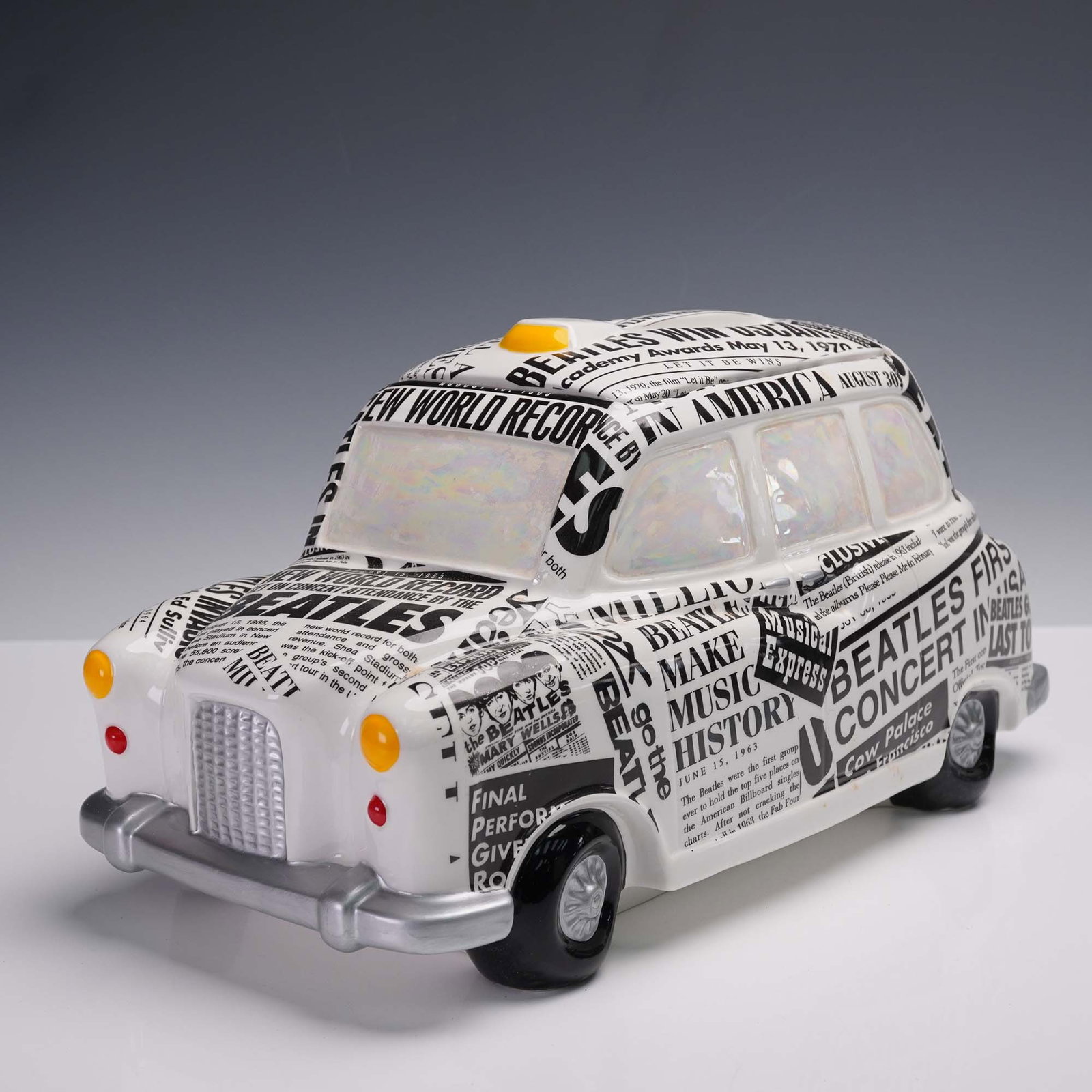 Beatles Newspaper Taxi Cookie Jar by Vandor: Get ready to add a pop of nostalgia to your kitchen with this Beatles Newspaper Taxi cookie jar by Vandor. Designed as a charming London cab, its splashed with iconic newspaper headlines chronicling t