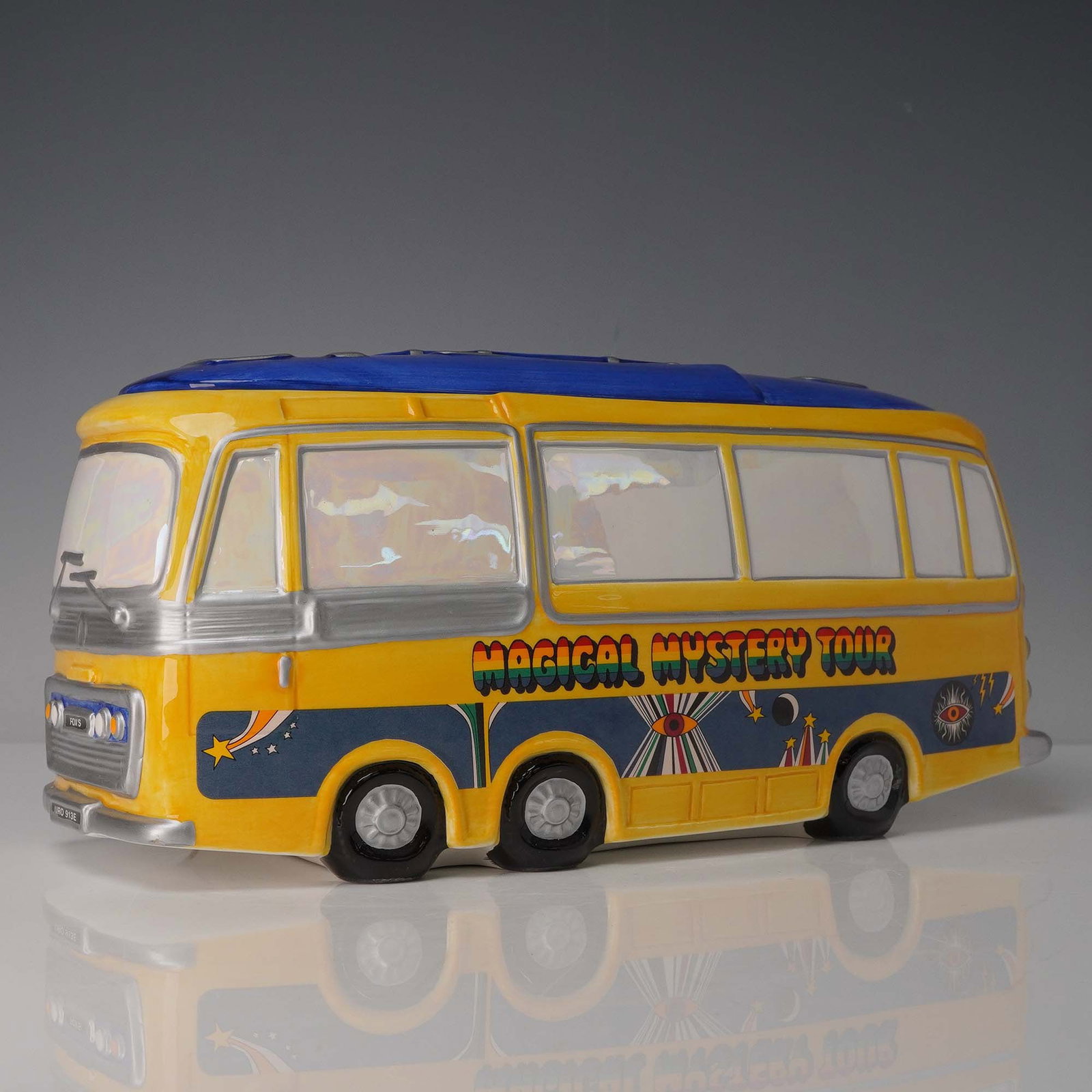 The Beatles Magical Mystery Tour Cookie Jar by Vandor: This officially licensed ceramic cookie jar by Vandor celebrates The Beatles' Magical Mystery Tour with bold colors and psychedelic styling inspired by the 1967 film and album. This limited edition sc