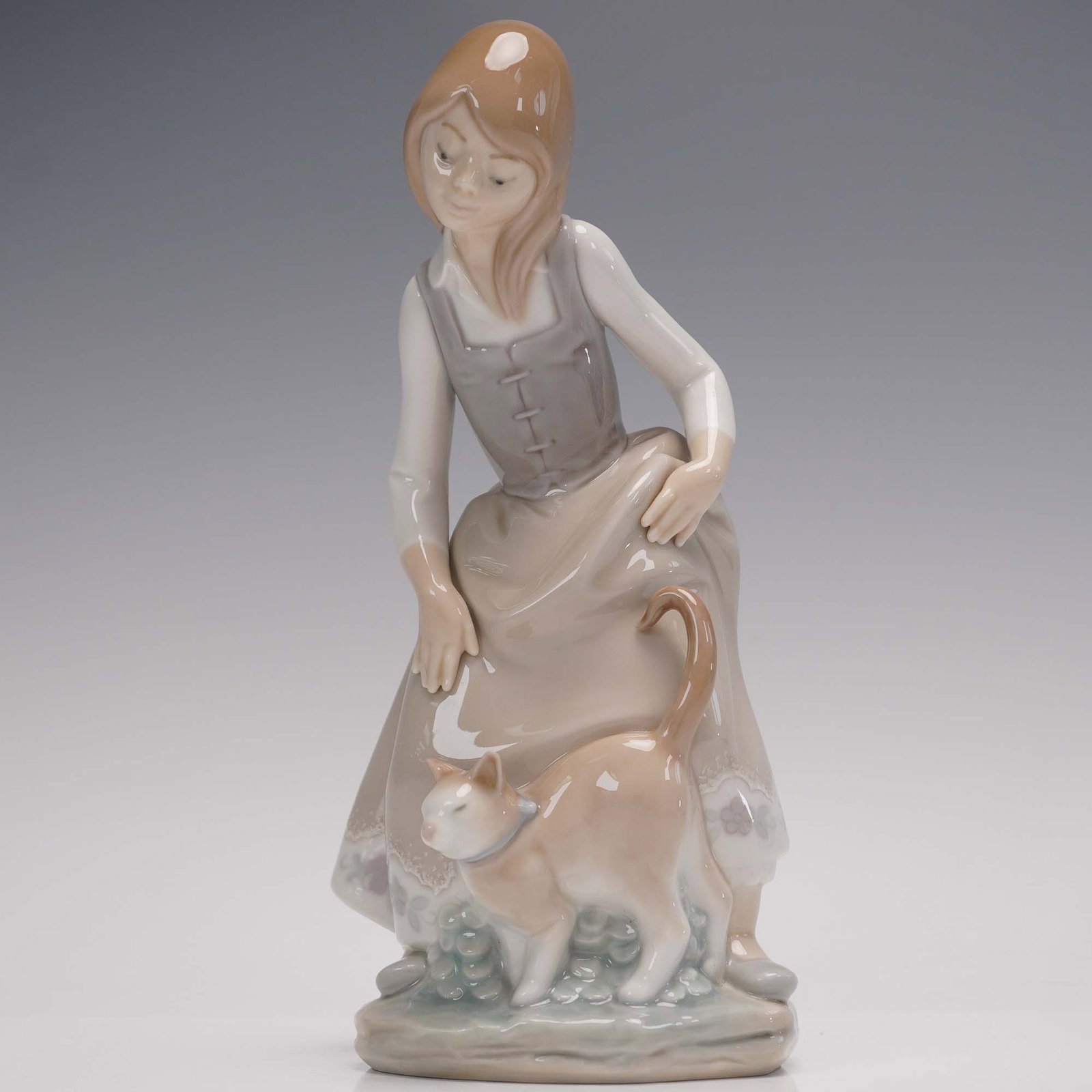 Lladró Little Girl with Cat Porcelain Figurine 1187" Retired: This charming Lladró porcelain figurine, titled "Little Girl with Cat" (model #1187), was sculpted by Juan Huerta and issued in 1972. It was retired in 1990, making it a sought-after piece among coll