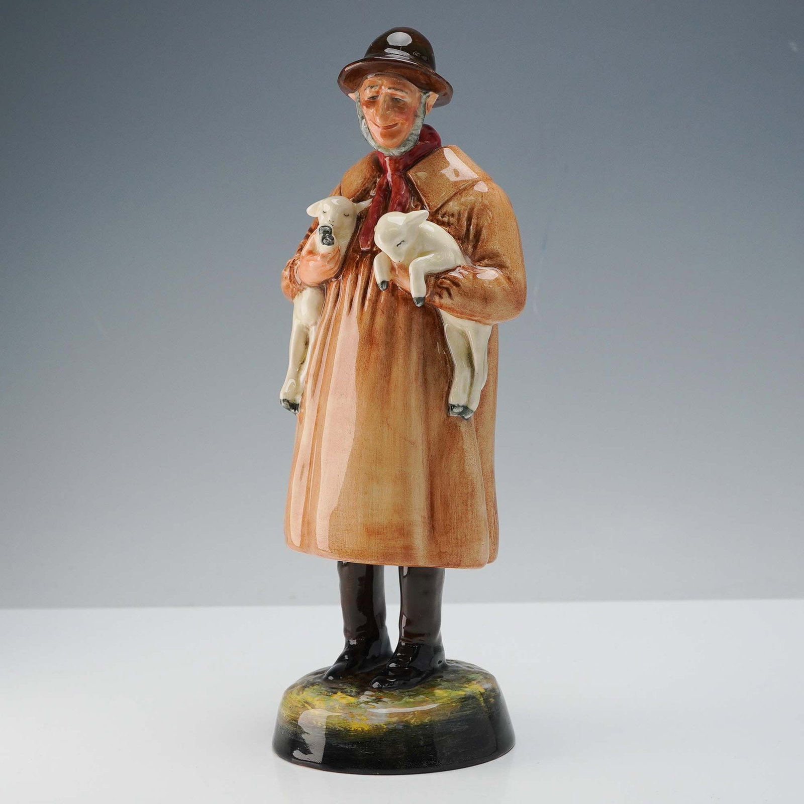 Royal Doulton Figurine, Lambing Time HN1890: Royal Doulton figurine titled Lambing Time, model HN1890, designed by Leslie Harradine. This charming figure captures a young woman seated with a lamb in her lap and a ewe standing beside her, express
