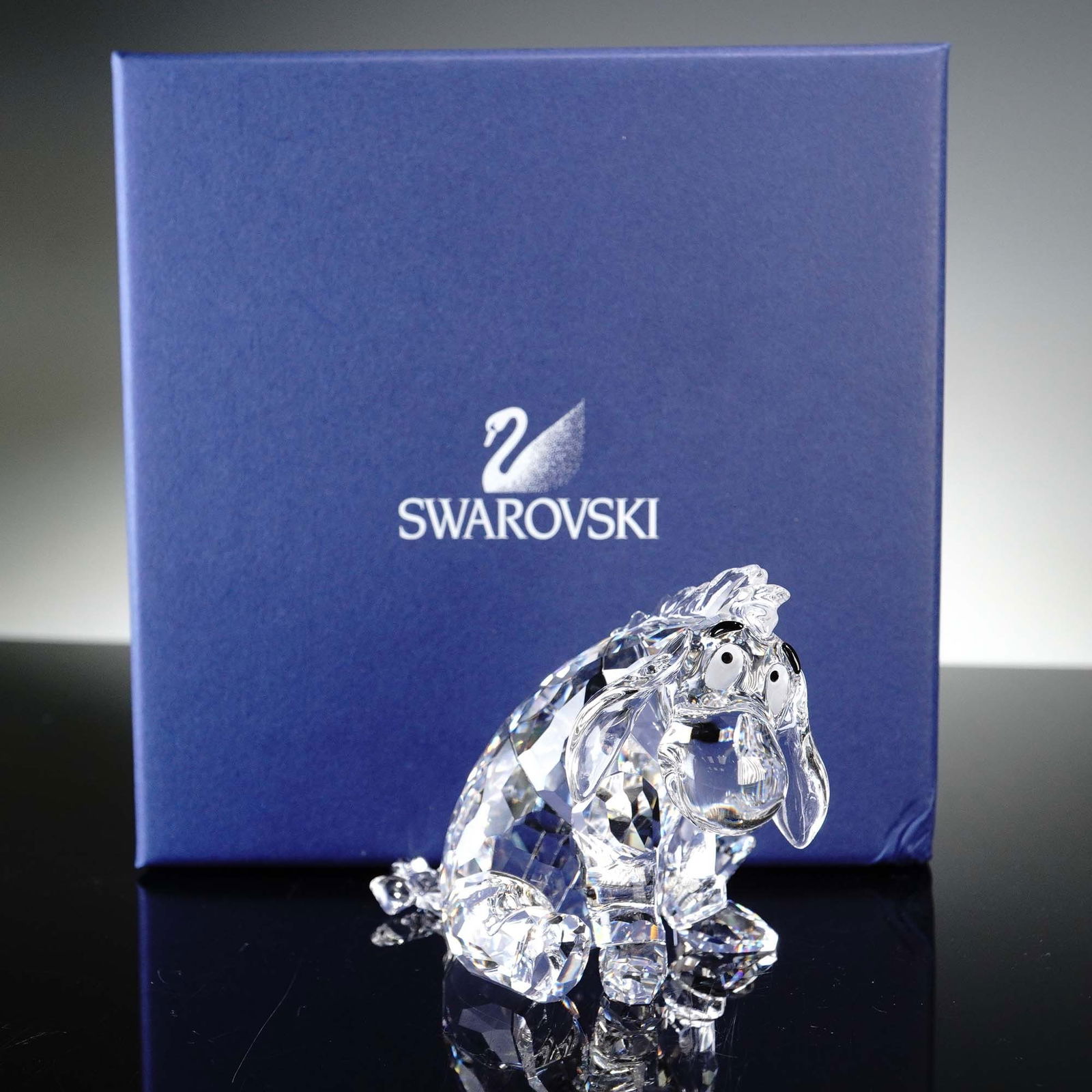 Swarovski Crystal Figurine, Eeyore Disney Winnie the Pooh Series: This captivating Swarovski crystal figurine depicts Eeyore from Disney's beloved "Winnie the Pooh" series. Eeyore is crafted in fully faceted clear crystal that beautifully refracts light, giving a sp