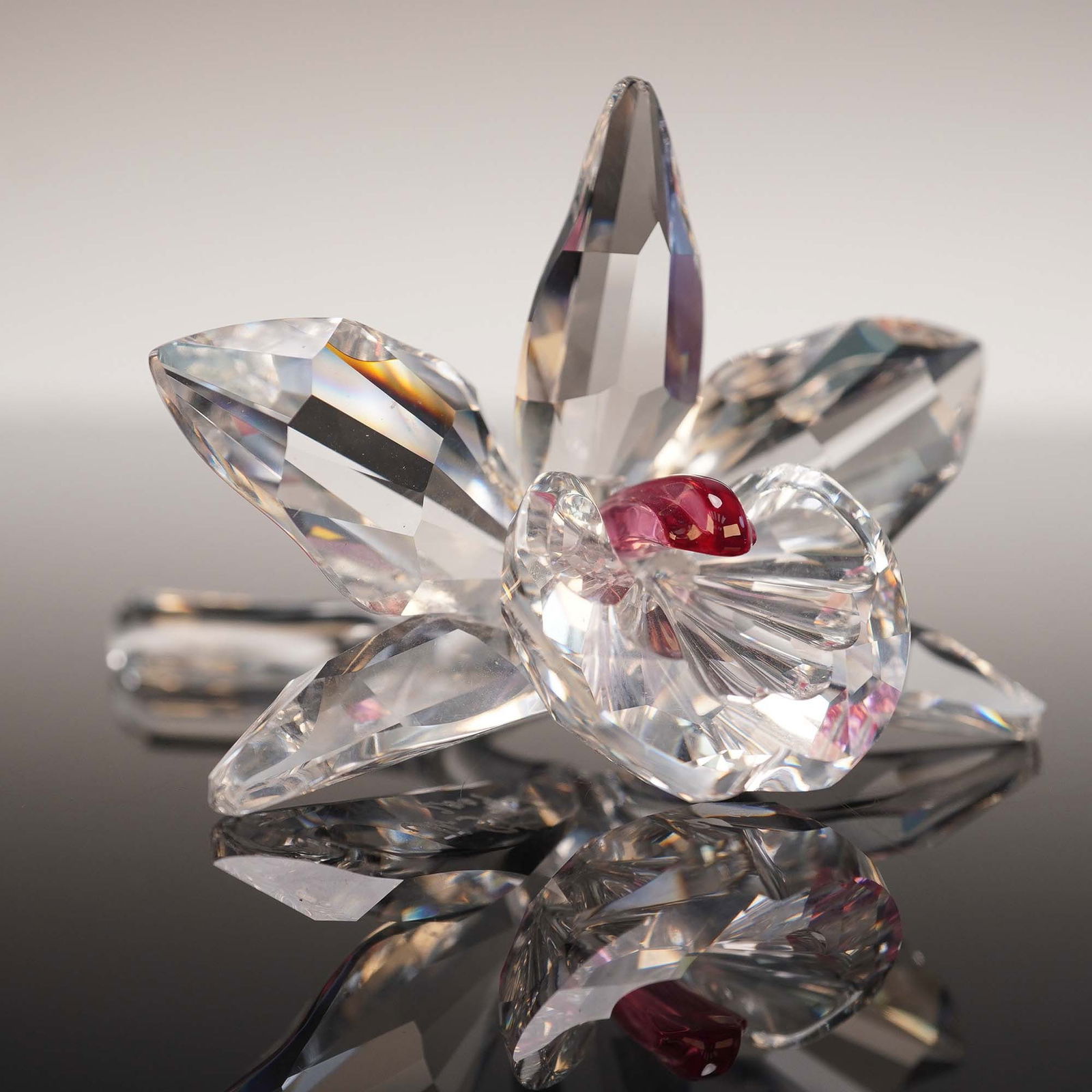 Swarovski Crystal Figurine, The Orchid Pink: Lead crystal part of the Exquisite Accents collection. A singled clear blossom orchid with a pink center, sitting on a small pillow for display. Swarovski backstamp. This item has its original box. Bo