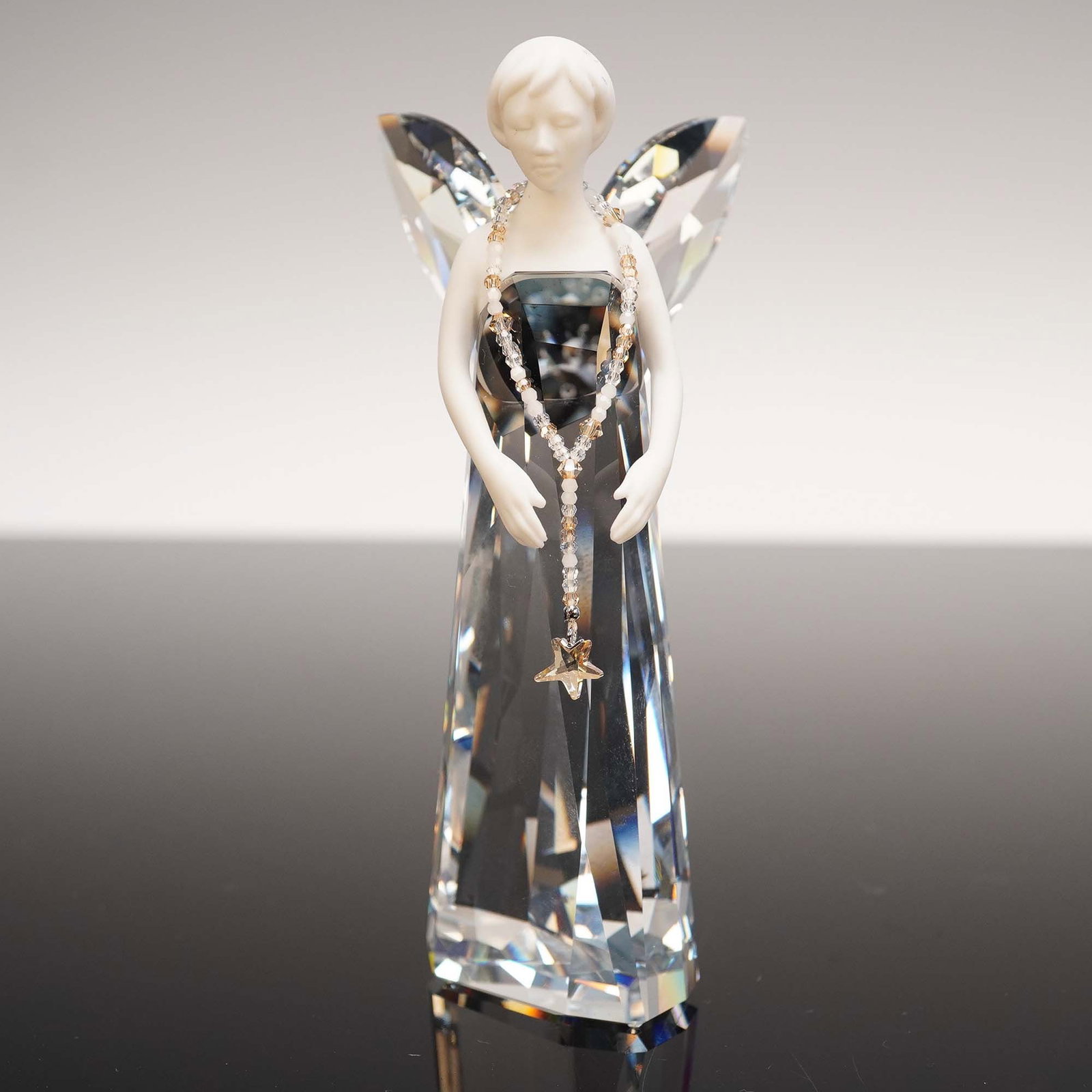 Swarovski Crystal Figurine, Angel of Grace with Star Necklace w/ Box: This radiant Swarovski Crystal Angel of Grace figurine showcases the brand's mastery in combining ethereal elegance with precision craftsmanship. Featuring a brilliant faceted crystal gown and wings, 