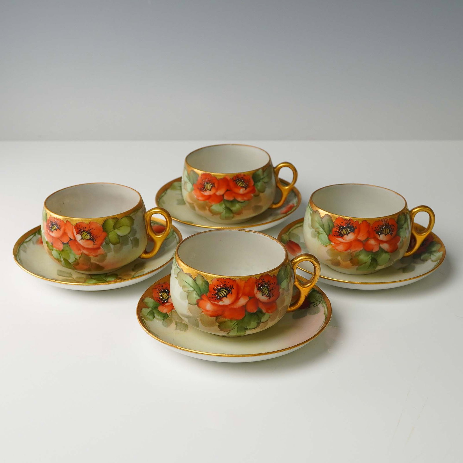 4pc Freiberg Hand Painted Cup and Saucer Sets: Offered is a delightful collection of four hand painted cup and saucer sets, each showcasing intricate floral motifs in a variety of colors and patterns. The cups feature gently flared rims and delica