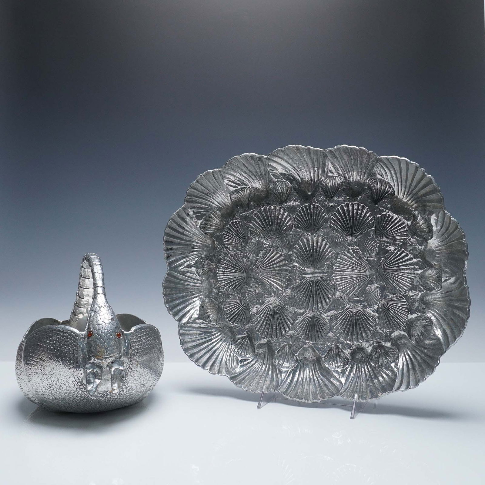 2pc Arthur Court Aluminum Serveware, Armadillo Basket and Shell Platter: Whimsical pair of aluminum serveware pieces by Arthur Court Designs, including a sculpted armadillo-form handled basket and a matching oval platter with a high-relief shell motif. The armadillo basket