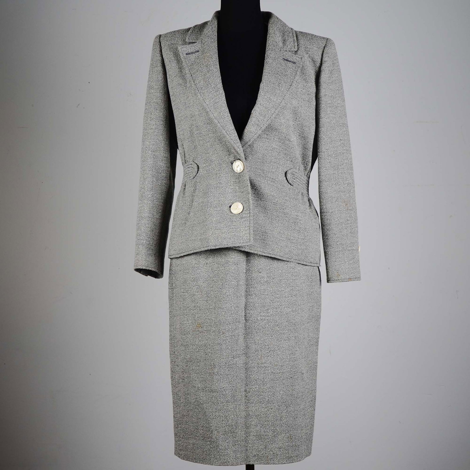 Valentino Boutique Gray Belted Skirt Suit with Pearl Buttons, Size 8: This vintage Valentino Boutique two-piece skirt suit showcases the brand's signature Italian elegance with a structured silhouette and refined detailing. Crafted in a gray speckled wool blend, the jac
