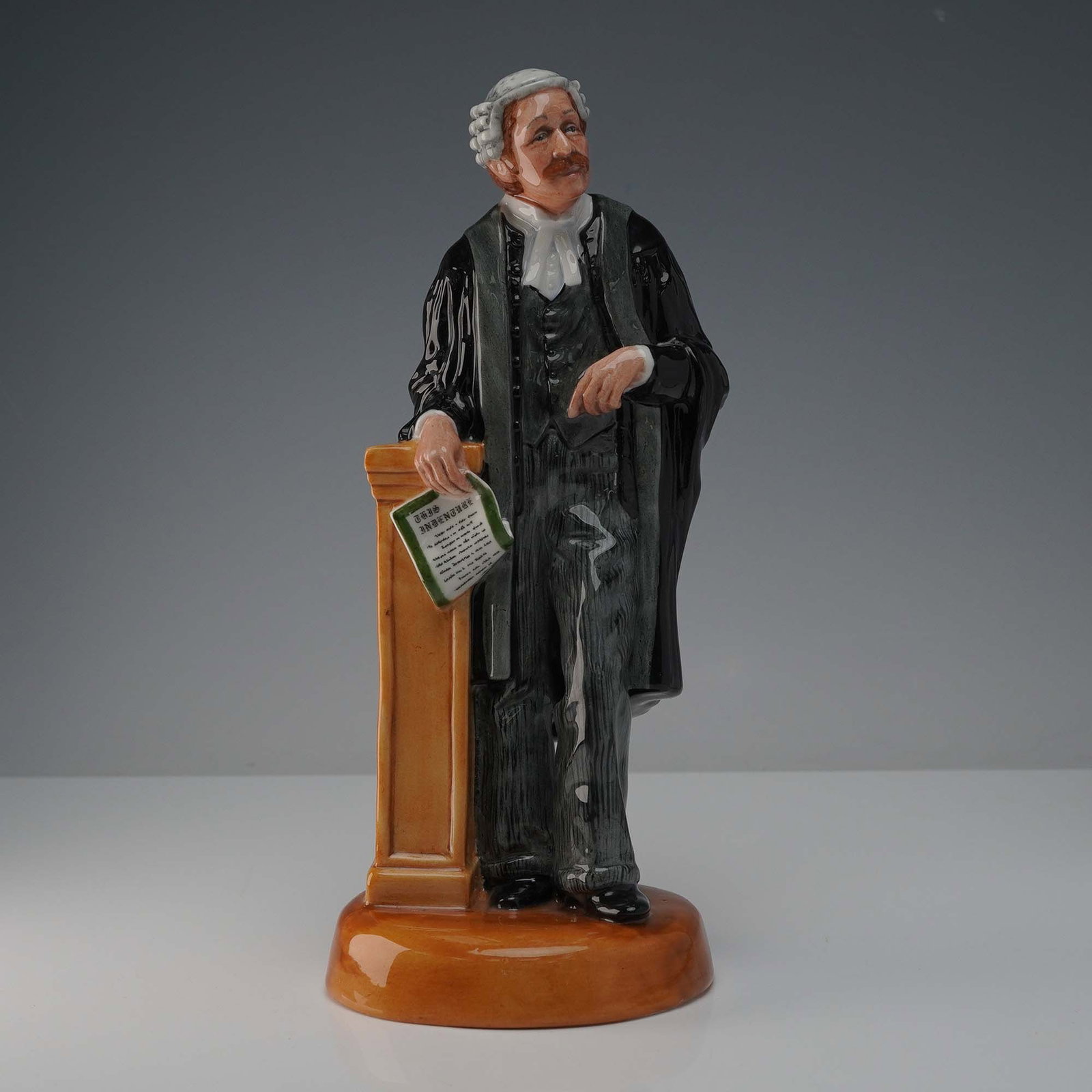 Royal Doulton Figurine, The Lawyer HN3041: Glossy finish figure depicting a poised and confident lawyer in a traditional wig and robe, embodying the dignity and professionalism of the legal profession. Royal Doulton backstamp. Artist: Pauline 
