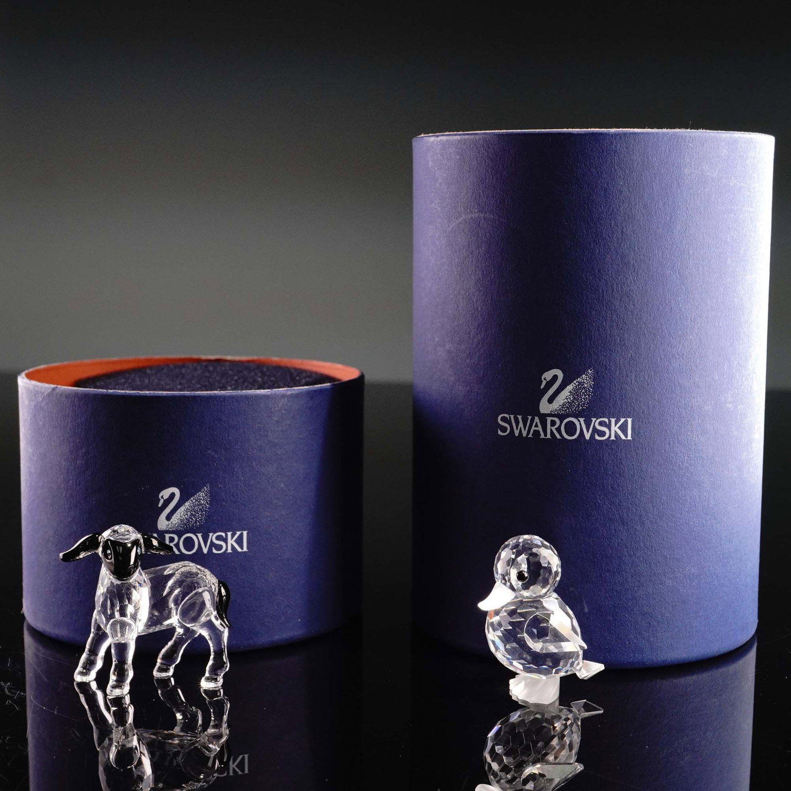 2pc Swarovski Crystal Figurines - Little Blackhead Lamb, Mini Standing Duck: A delightful 2-piece lot of Swarovski crystal figurines. The Little Blackhead Lamb features a distinctive design with a black crystal face, tail, and ears that contrast beautifully with the clear crys
