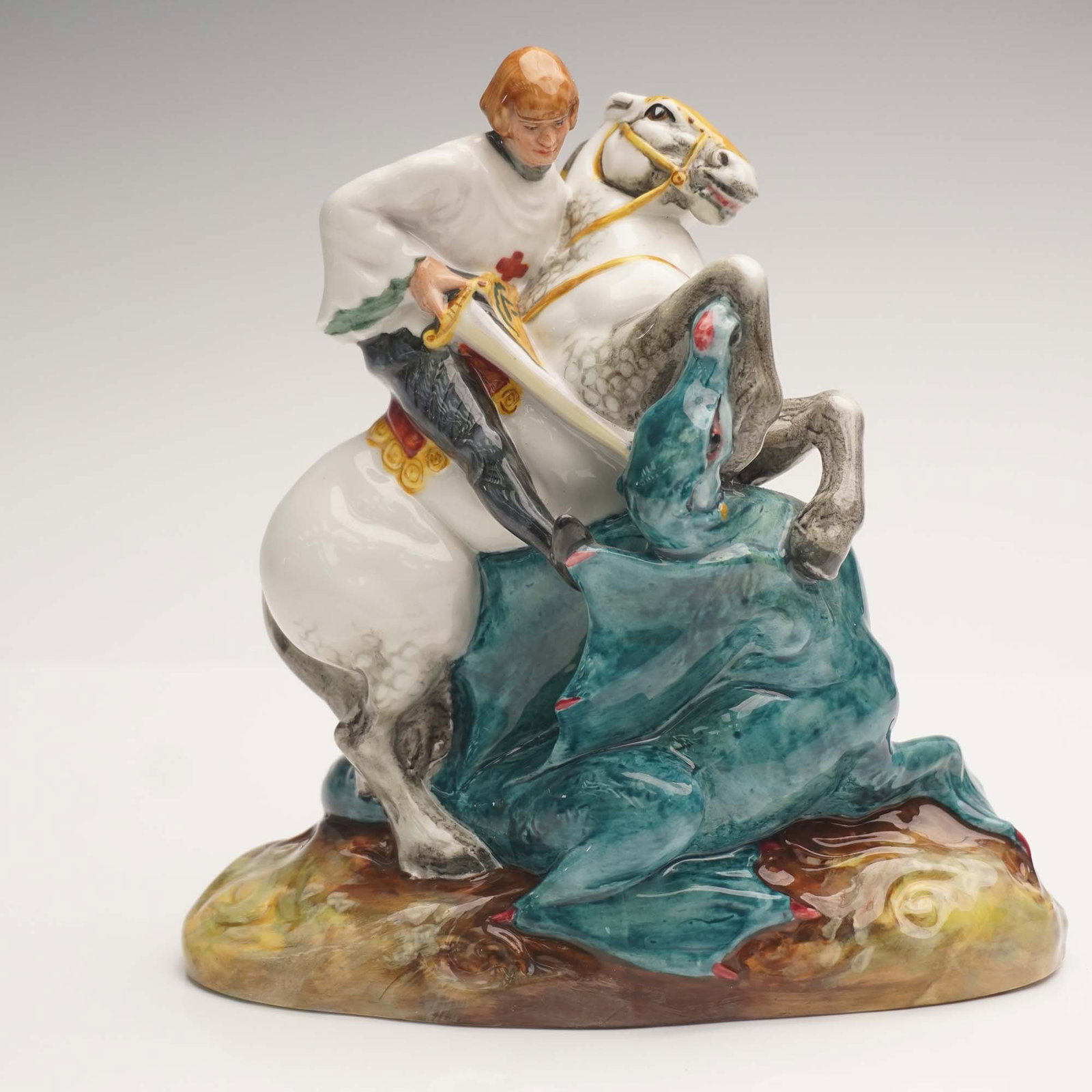 Royal Doulton Figurine, St George HN2051: Royal Doulton figurine titled St. George, model HN2051, depicting the legendary knight mounted on horseback in the act of slaying a dragon. Designed with vivid color contrasts and dynamic motion, this