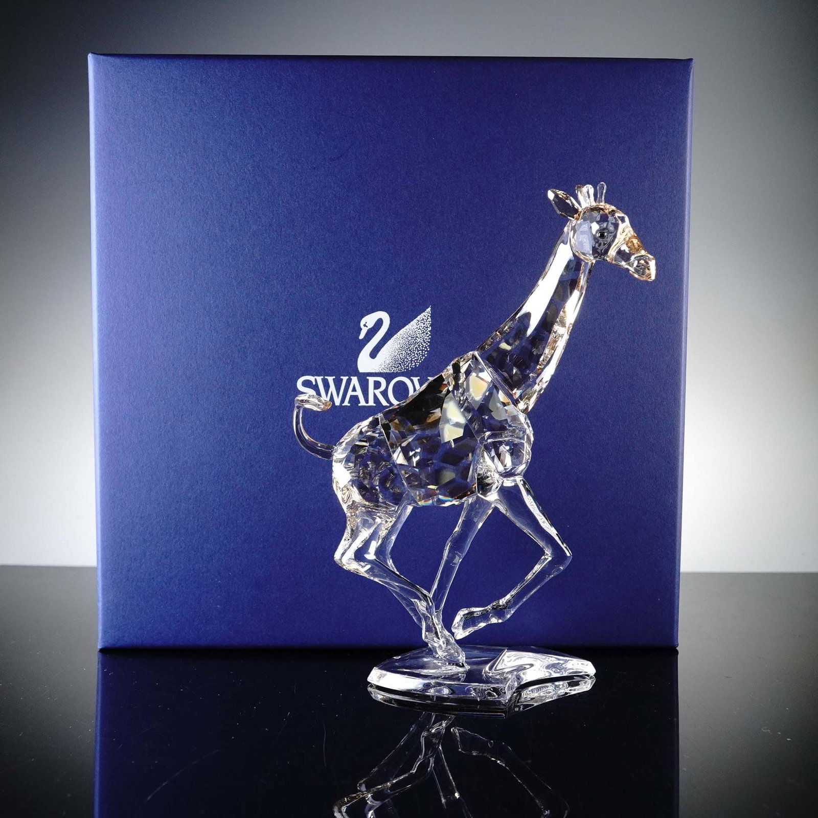 Swarovski Crystal Figurine, Running Giraffe: This dazzling Swarovski Crystal Running Giraffe figurine captures the elegant motion of the world's tallest animal with exceptional detail. Designed by Heinz Tabertshofer and introduced in 2008, this 