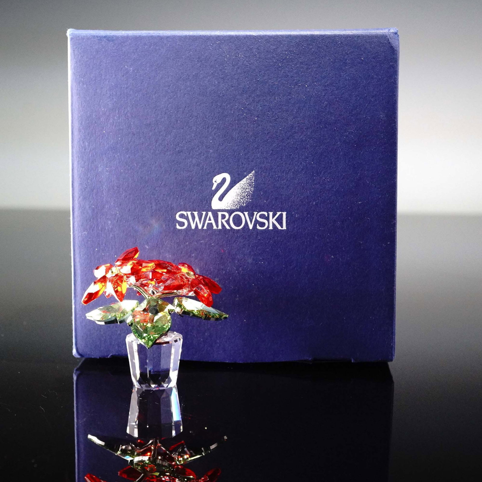 Swarovski Crystal Figurine, Poinsettia Small: This elegant Swarovski Poinsettia Small figurine is crafted in a festive combination of clear, red, and green crystal, with delicate branches rendered in polished metal. Introduced in 2017 and designe