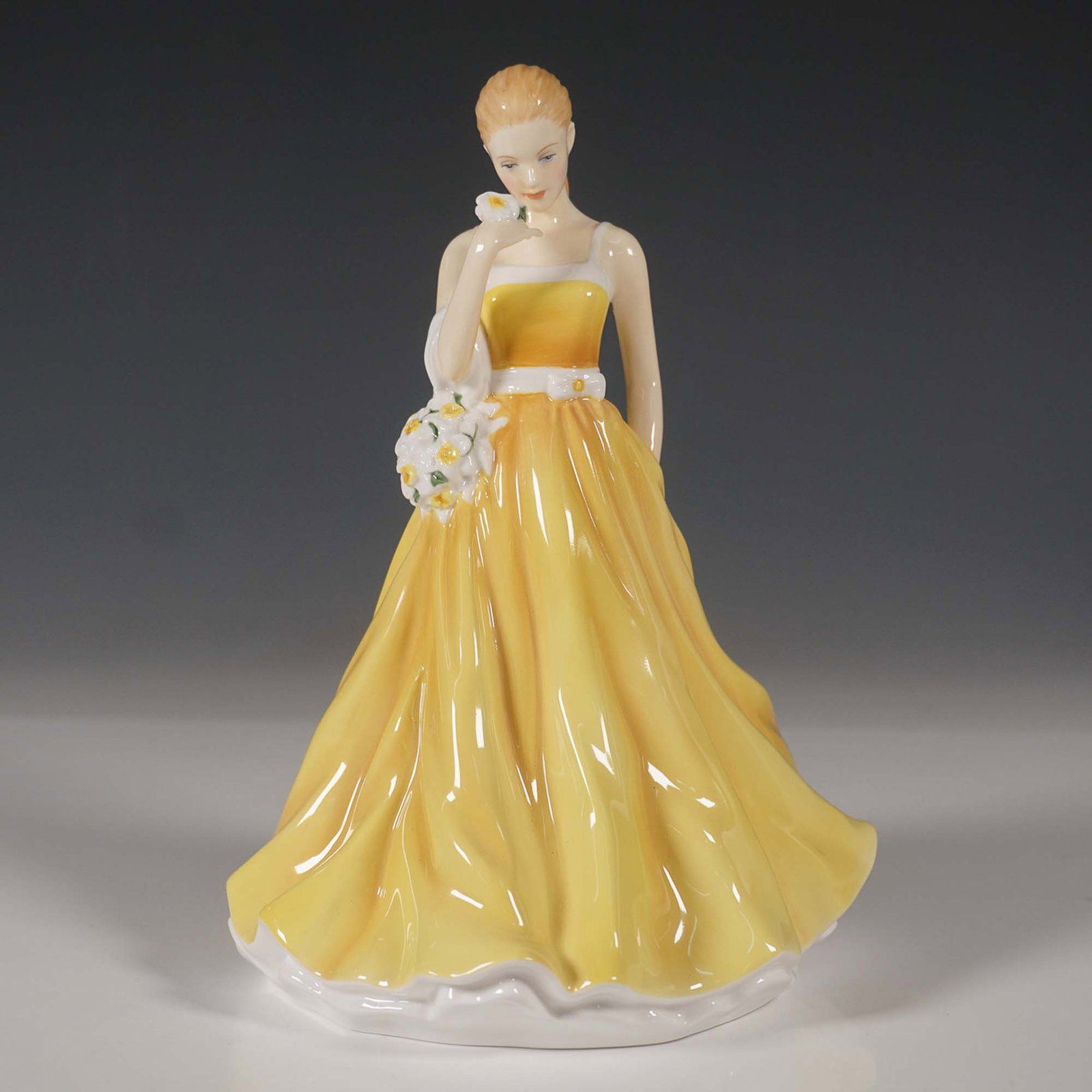 Royal Doulton Flower of the Month Figurine, March HN5502: A beautiful Royal Doulton Flower of the Month figurine, March Jonquil Devotion, model HN5502. This hand-made and hand-decorated bone china figurine features a gracefully posed woman in a flowing yello