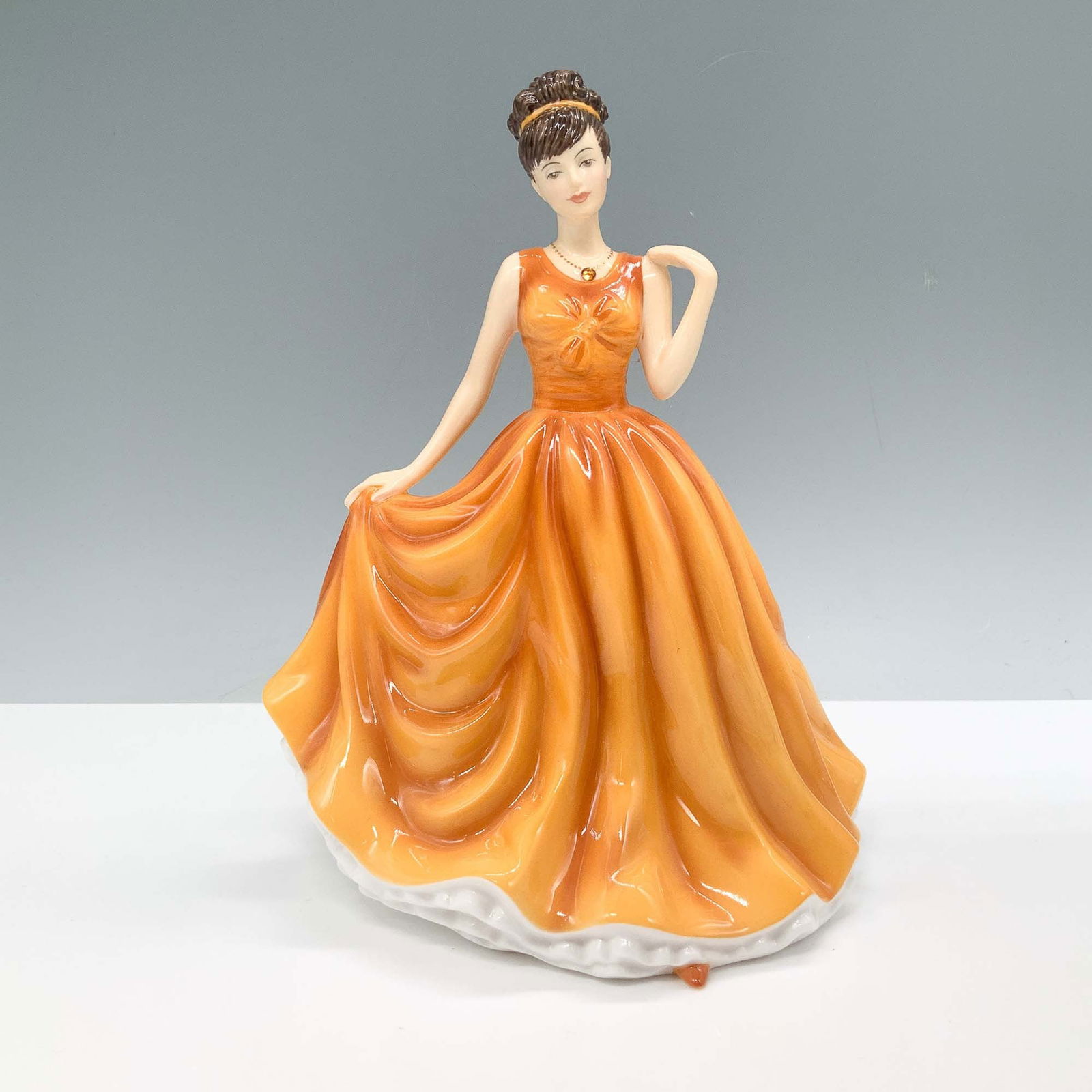 Royal Doulton Birthstones Figurine, November Topaz HN 5636: Royal Doulton Birthstones collection figurine titled November Topaz, model HN 5636. Crafted from fine bone china, this hand-decorated figurine depicts a graceful lady in an amber gown, representing th