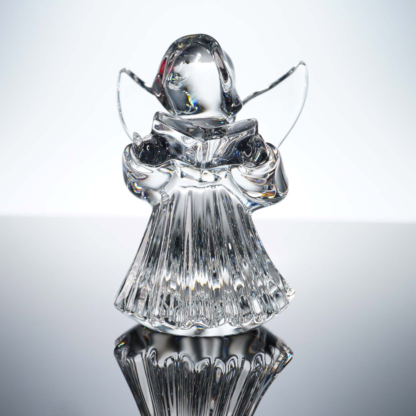 Baccarat Crystal Figurine, Guardian Angel with Songbook, Boxed: This exquisite Baccarat crystal figurine features a serene angel in a flowing, fluted robe, holding an open songbook in graceful hands. The elegant clear crystal design showcases Baccarat's signature 