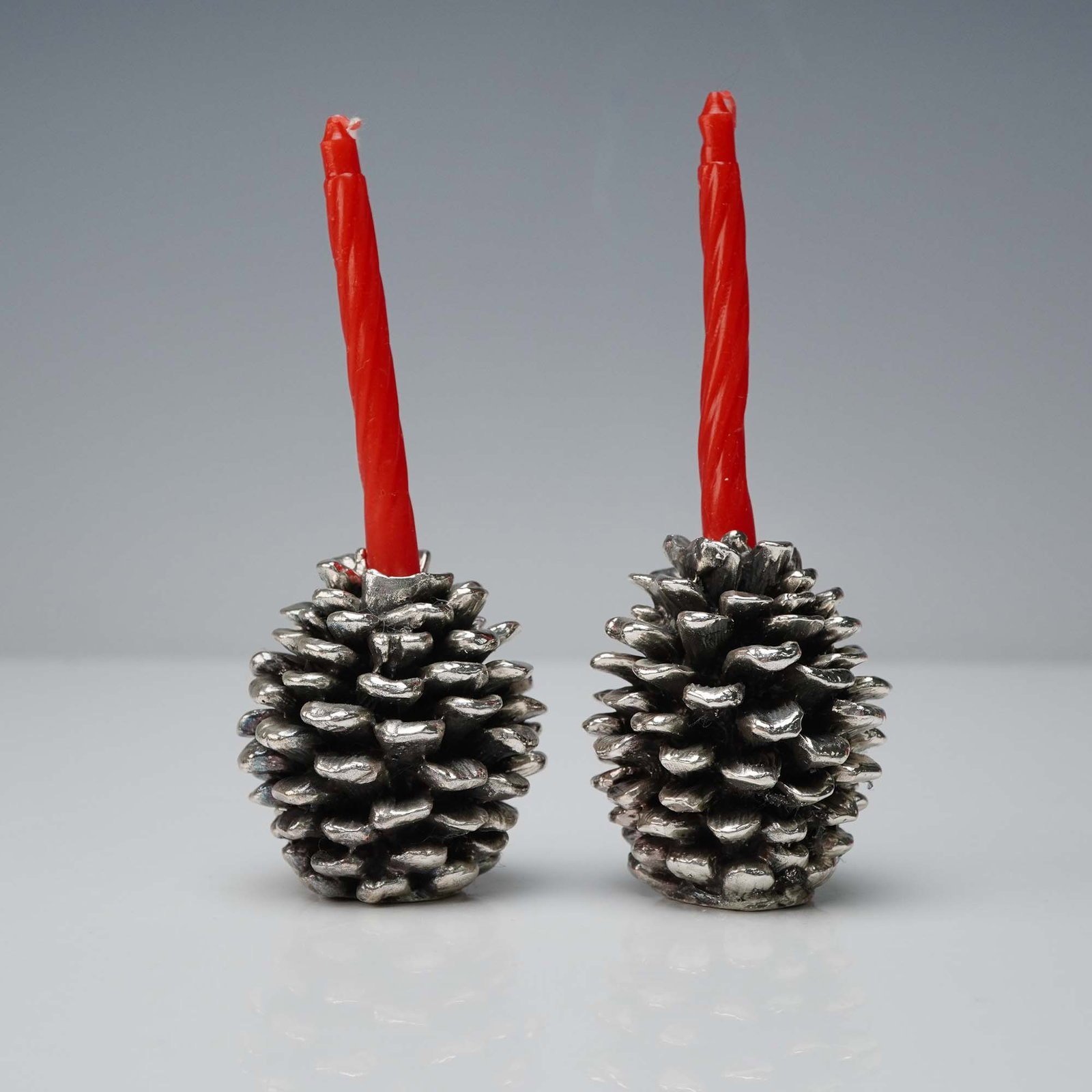 2pc Scully & Scully Pinecone Candle Holders: This elegant 2-piece set of silver-toned pinecone candle holders is by Scully & Scully, New York, known for offering refined home accessories and luxury goods. Sculpted with remarkable detail to resem