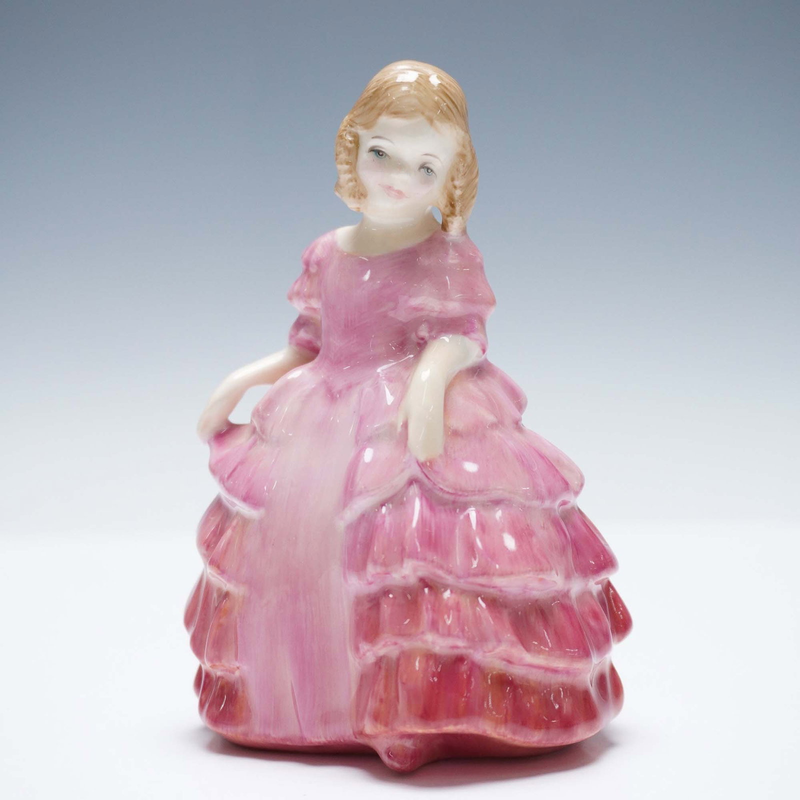 Rose HN1368 - Royal Doulton Figurine: Charming Royal Doulton bone china figurine titled Rose, model HN1368, featuring a young girl dressed in a cascading pink ruffled gown with delicate facial detailing and golden blonde curls. This hand-