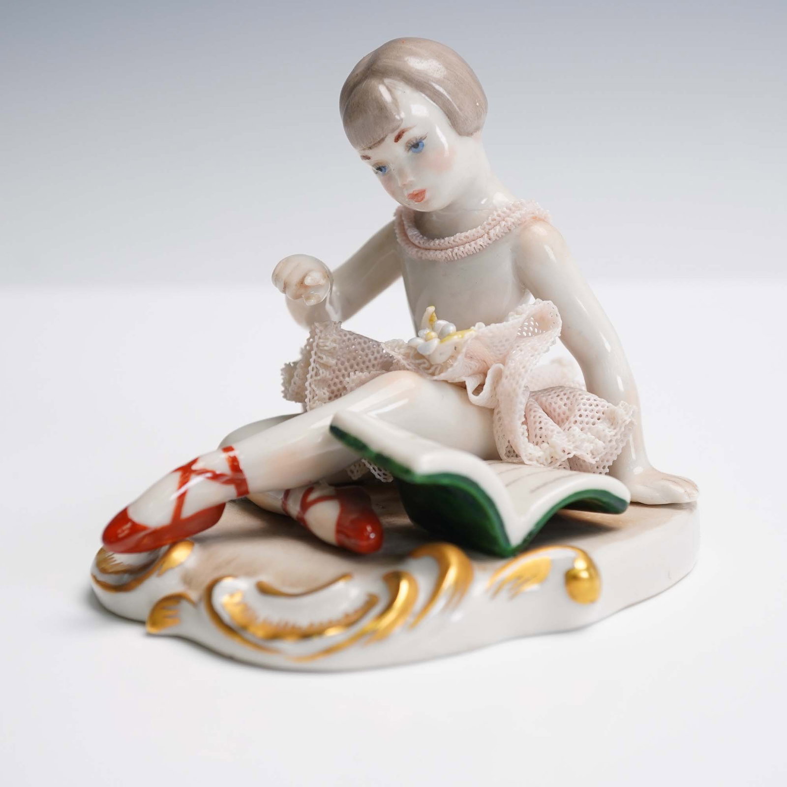 Lladro Porcelain Figurine, Girl With Book Open 1000112: This charming Lladro porcelain figurine depicts a seated girl thoughtfully reading an open book and showcases the delicate lace skirt technique for which Lladro is renowned. It was sculpted by Amparo 