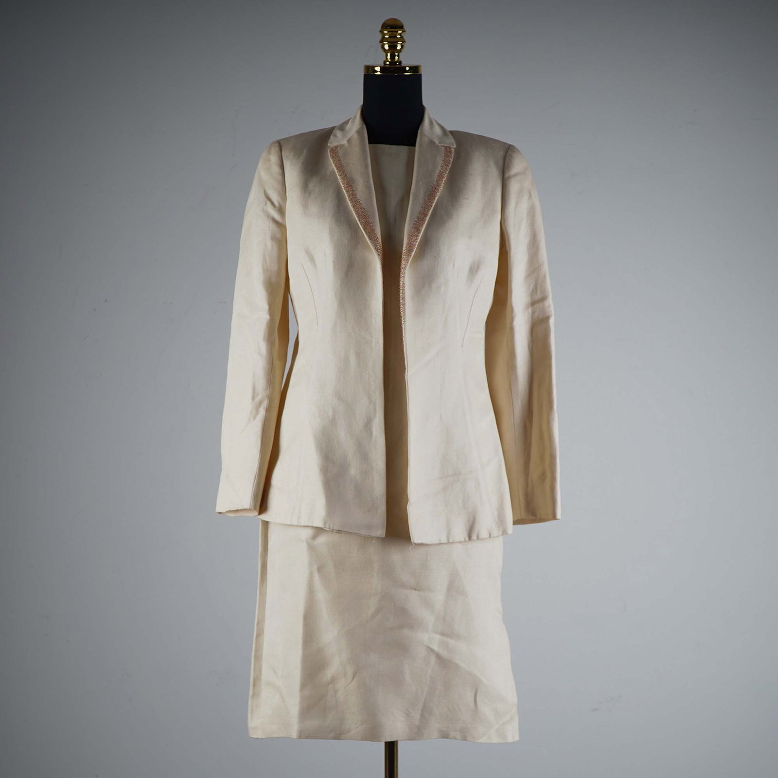 Valentino Miss V Cream Lined Linen Skirt Suit, Size 8: This sophisticated skirt suit by Valentino Miss V is crafted in a creamy linen fabric and features a tailored long-sleeve jacket with delicate pink and green beaded trim along the lapel. The jacket is