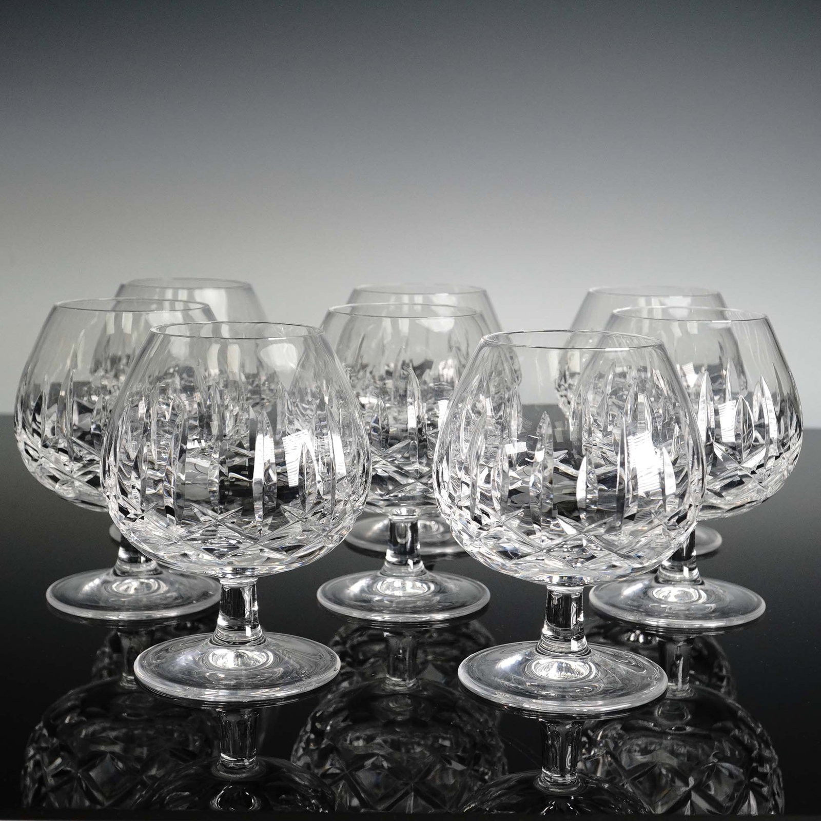 8pc Waterford Crystal Brandy Glasses, Mourne: These eight Waterford Crystal Mourne brandy glasses feature an iconic acid-etched diamond and wedge pattern that scatters light with every pour and are hand-made in Ireland by Waterford; the broad sni