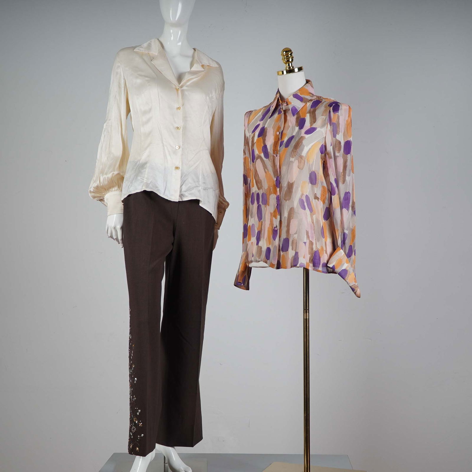 3pc Escada Silk Tops and Embellished Pants Ensemble: This sophisticated 3-piece Escada ensemble includes two silk blouses and one pair of embellished pants. The first blouse is a classic ivory silk button-down with romantic puffed sleeves and elegant sh