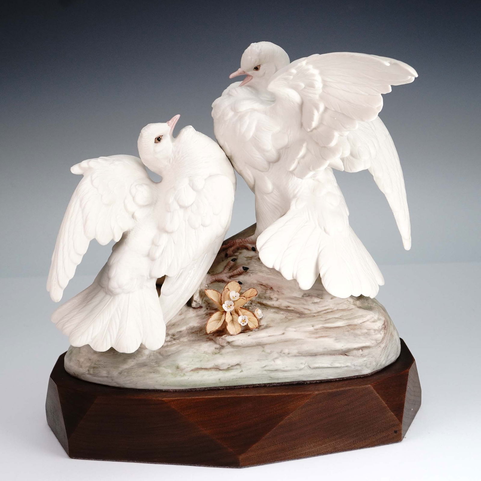 Cybis Porcelain Figurine, White Doves on Branch: Elegant Cybis porcelain figurine depicting two white doves perched on a branch with floral detail, symbolizing peace and love. Signed Cybis #475 and mounted on a faceted wood base. Known for its hand-