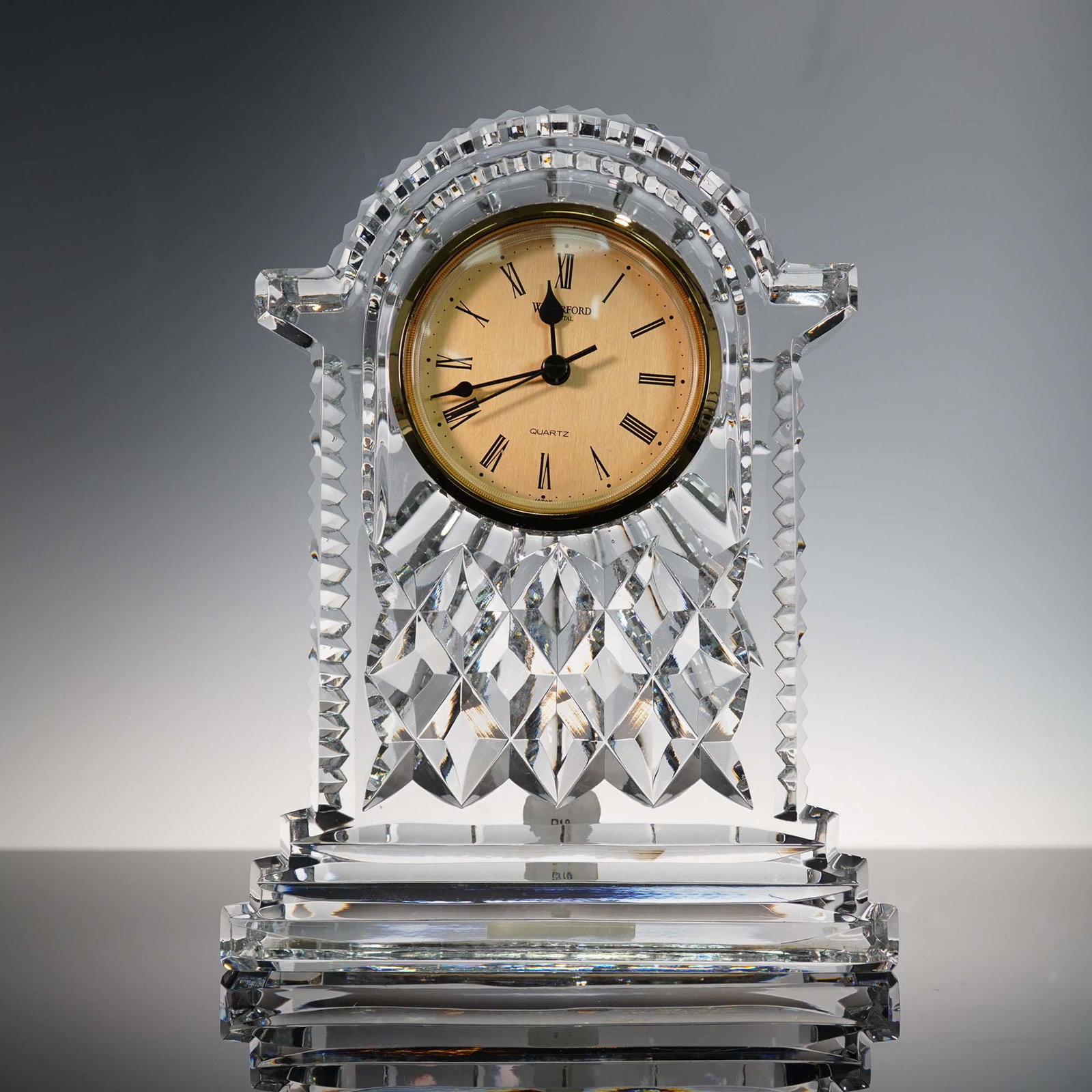 Waterford Crystal Carriage Clock with Gold Face: This Waterford Crystal carriage clock features a striking arched silhouette with diamond-cut detailing, topped by a classic round gold-tone quartz face with Roman numerals. The heavy, multi-faceted le