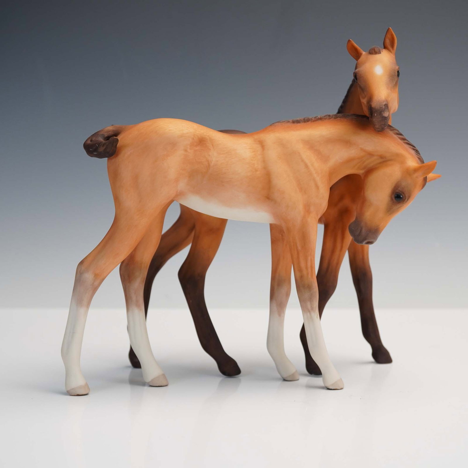 Cybis Porcelain Figurine, Pair of Colts: This endearing porcelain sculpture by Cybis features a pair of colts nuzzling affectionately, showcasing the American studio's exceptional craftsmanship in animal portraiture. Rendered in matte bisque