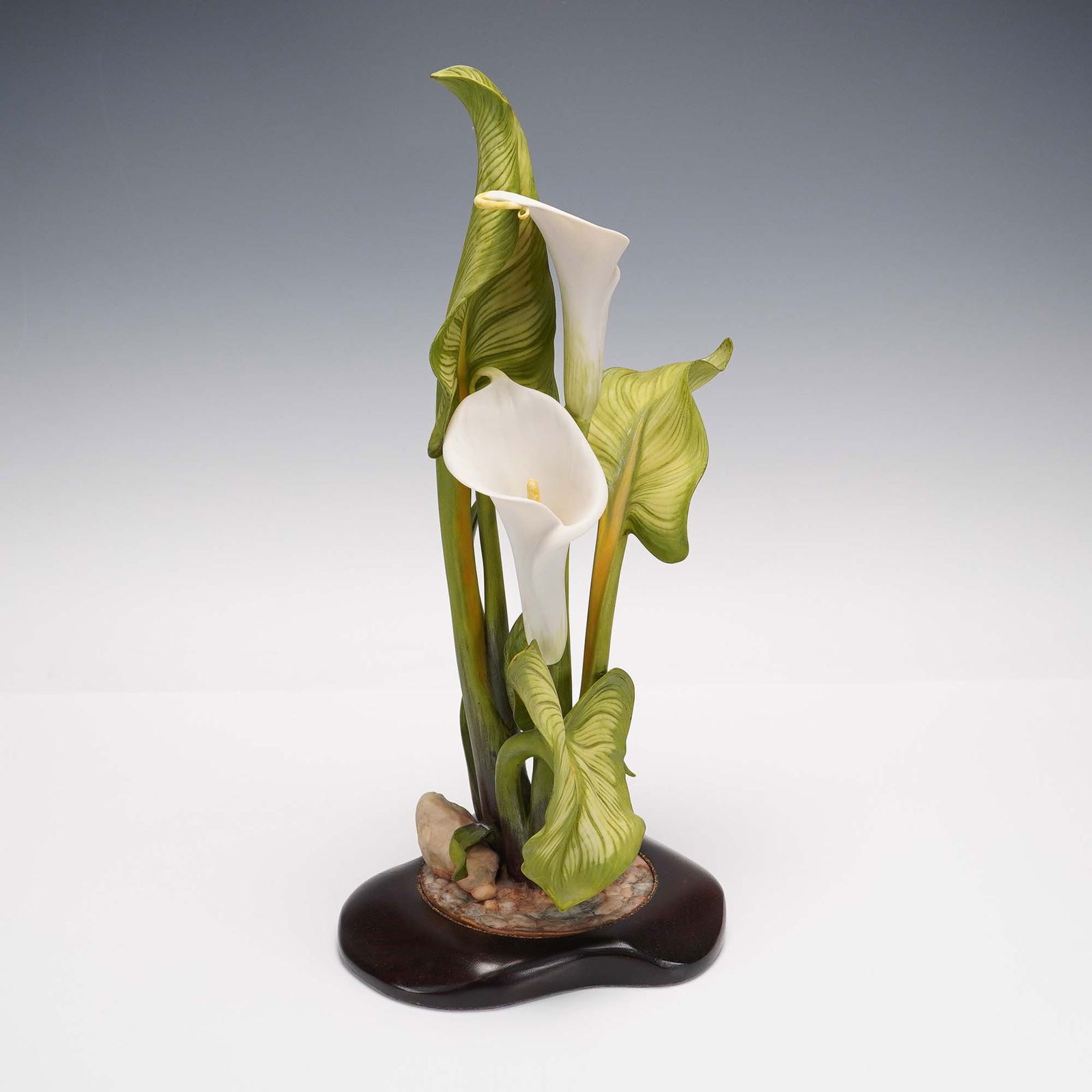 Cybis Porcelain figurine, Calla Lily: Elegant limited edition porcelain sculpture depicting a bouquet of white calla lilies surrounded by gracefully arching green leaves and long stems. The floral arrangement is mounted on a naturalistic