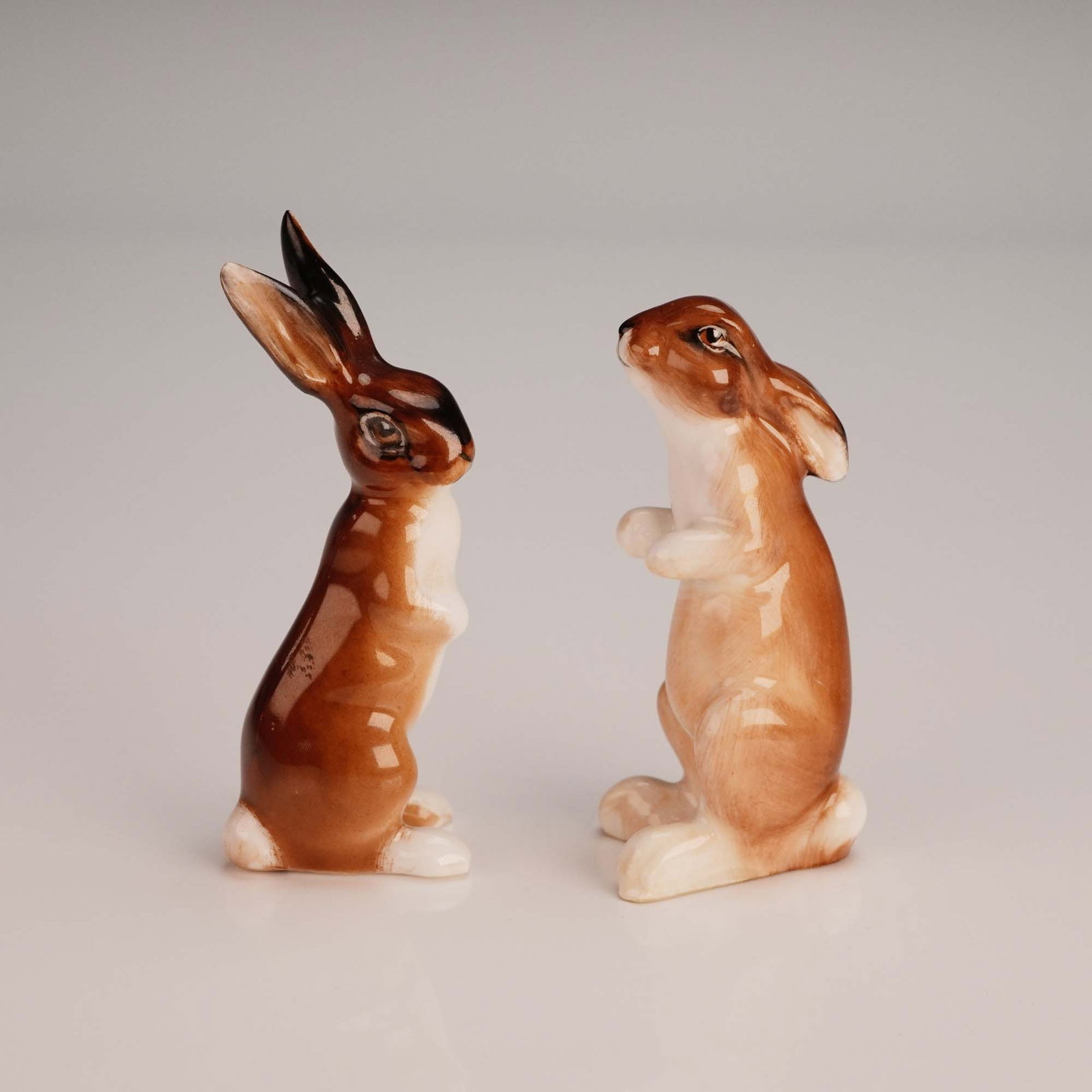 2pc Royal Worcester Bone China Figurines, Hares K38 & K39: A charming pair of Royal Worcester bone china figurines featuring two seated hares: Hare Seated Ears Down model K38 and Hare Seated Ears Up model K39. Both pieces are meticulously hand-painted in warm