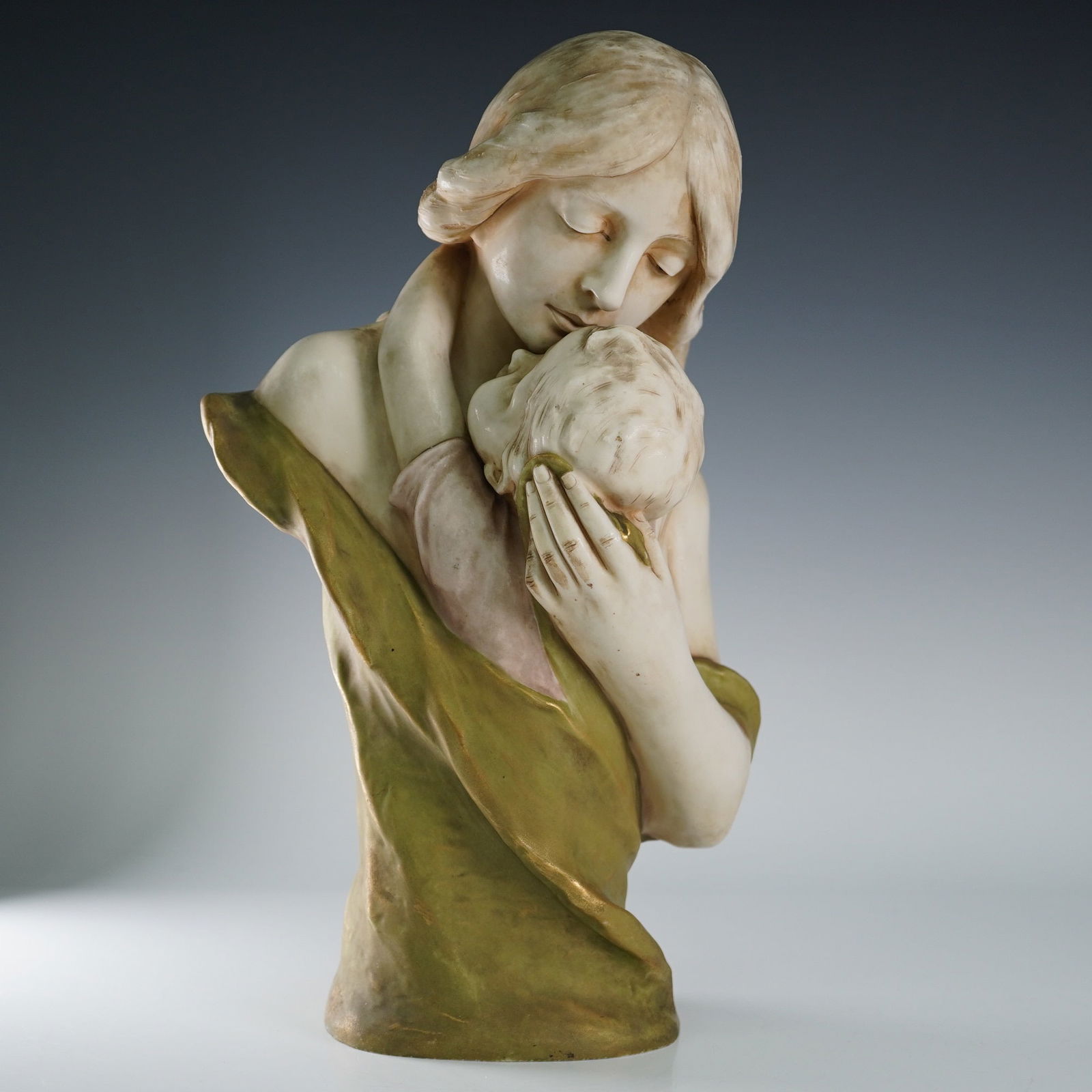 Royal Dux Porcelain Sculpture, Mother and Child: Graceful Royal Dux porcelain sculpture titled Mother and Child, depicting an Art Nouveau-style bust of a woman cradling and kissing a child. The elegant composition captures maternal affection through