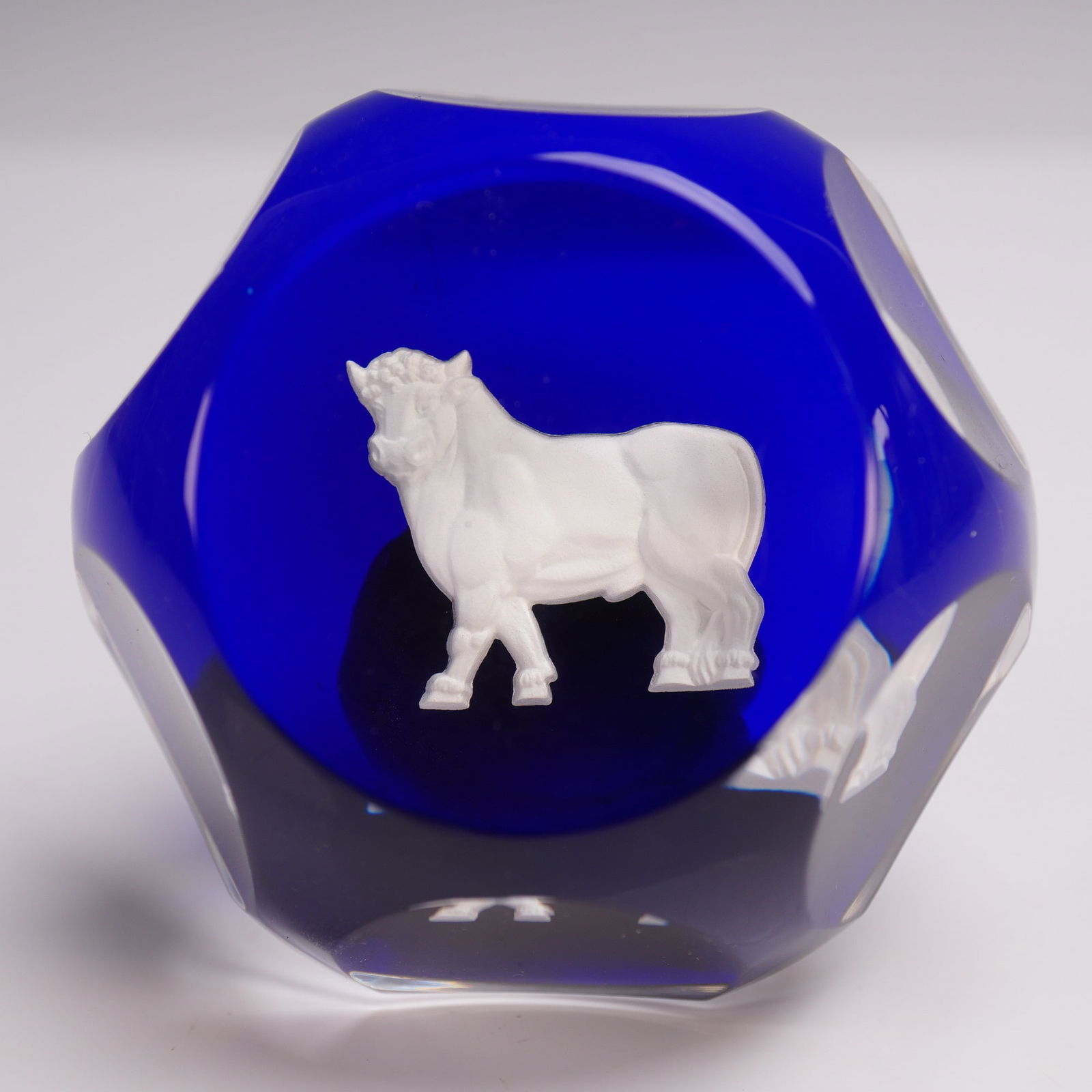 Baccarat Crystal Bull Paperweight: A magnificent example of Baccarat artistry, this striking crystal paperweight features a powerful bull rendered in frosted high relief. Set against a brilliant cobalt blue ground, the bulls sculptural