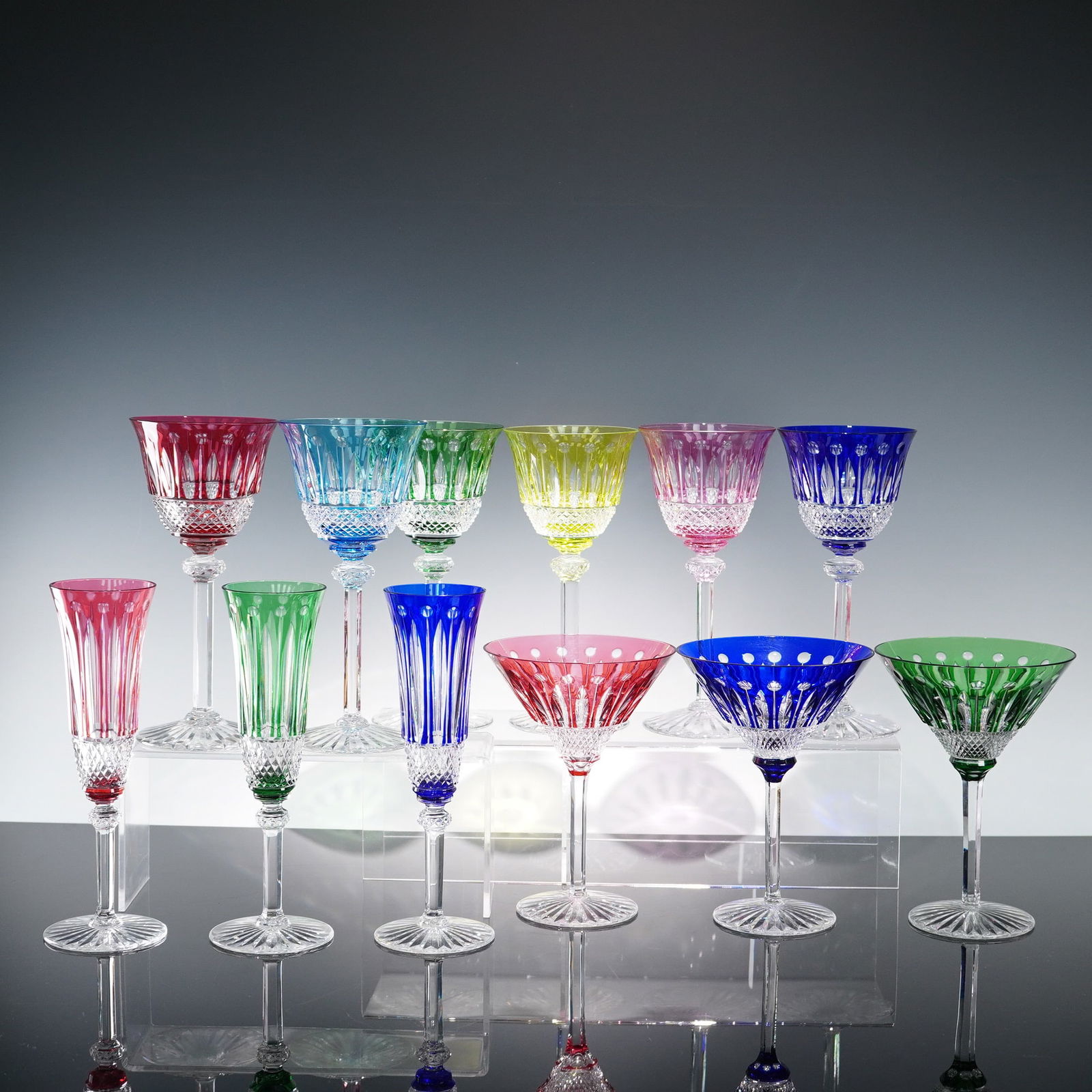 12pc Saint-Louis Crystal Colorful Stemware, Tommy: Collection of twelve Saint-Louis crystal stemware pieces from the Tommy pattern, featuring a vibrant array of colors and finely cut detailing. The lot includes three cocktail glasses in red, dark blue