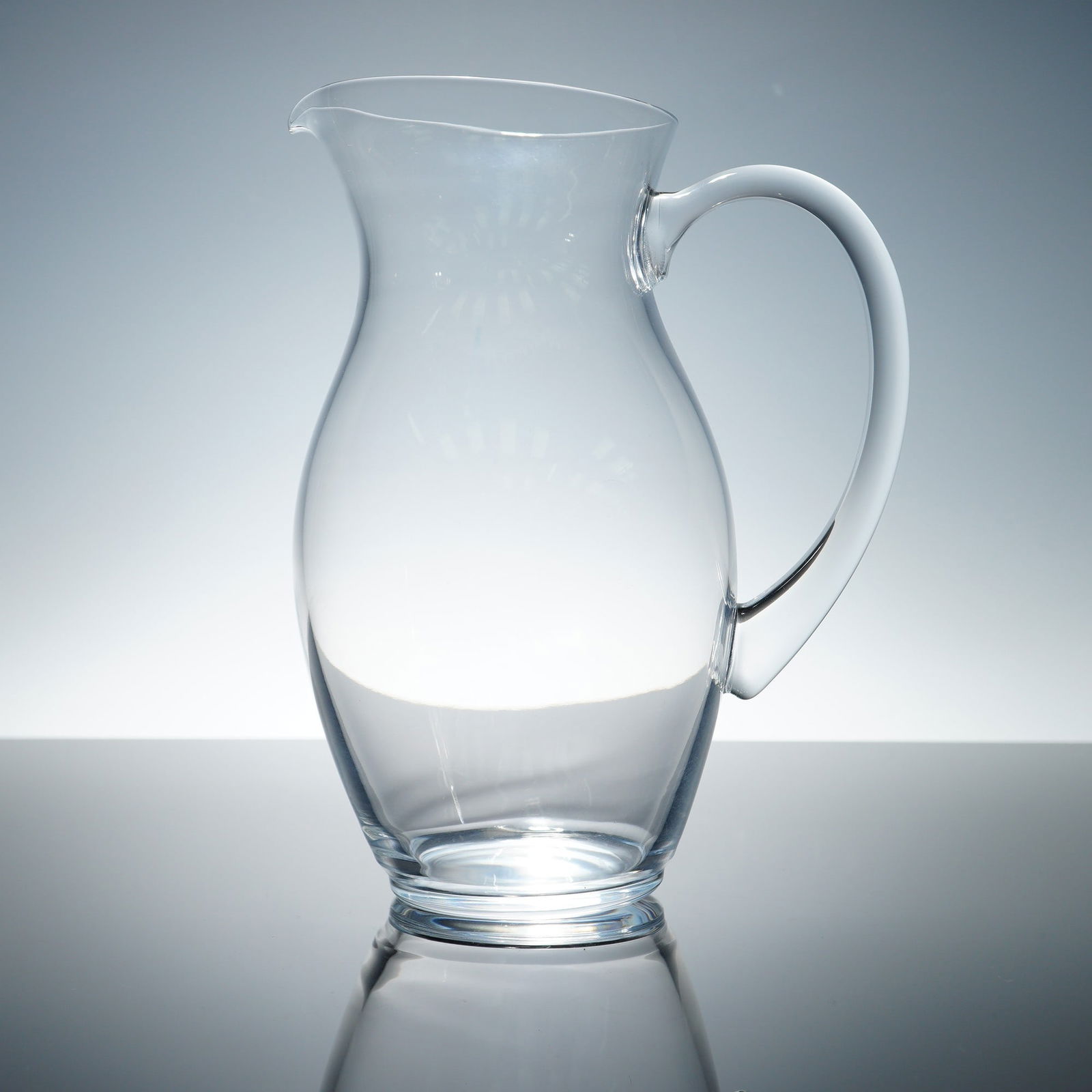 Christofle, Clear Crystal Water Pitcher: Elegant and timeless, this Christofle clear crystal water pitcher features a gracefully contoured silhouette with a wide belly, slender neck, and delicately flared spout. Its smooth, curving handle pr