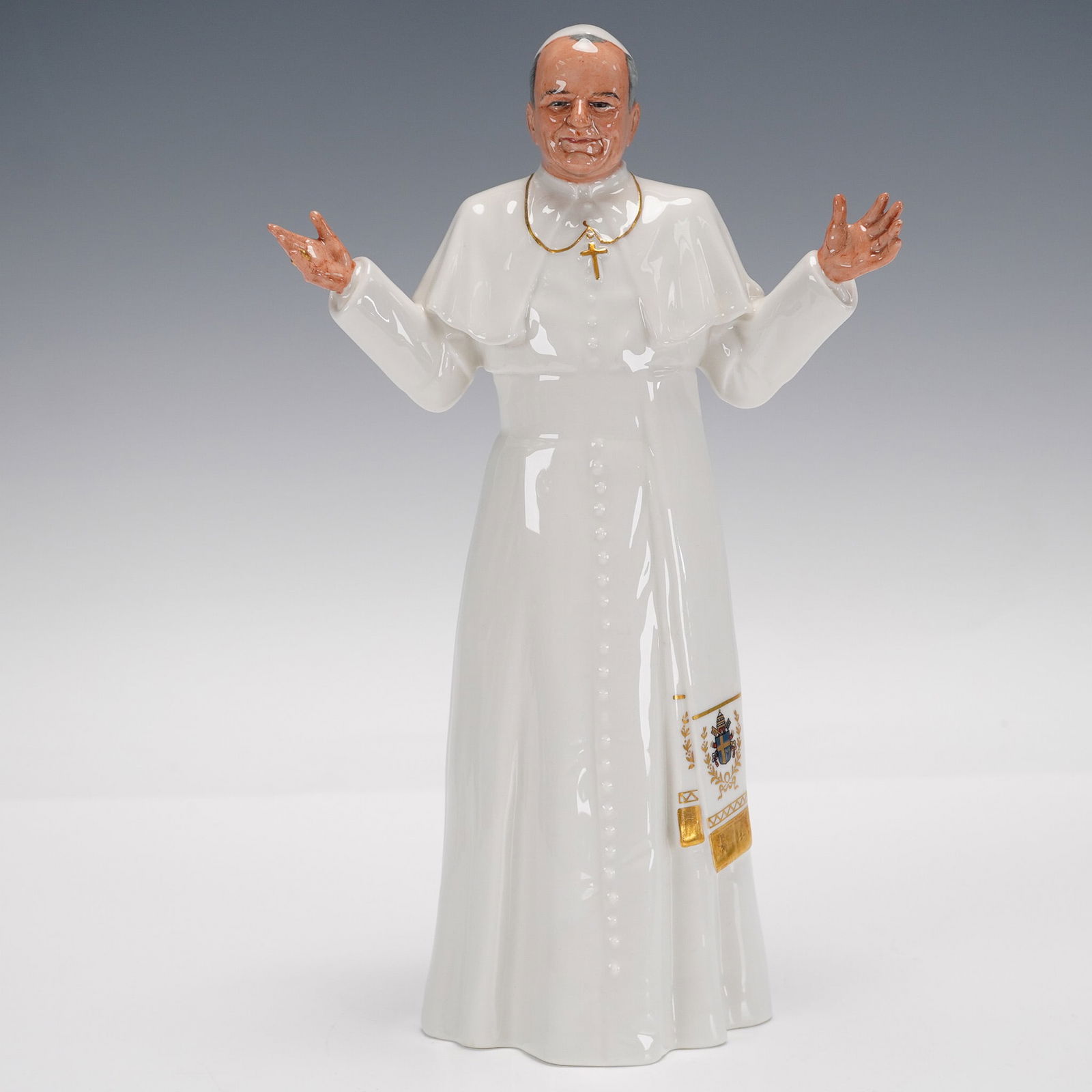 Royal Doulton Figurine, Pope John Paul II: Part of the Men of History series. A figure of Pope John Paul II in his white robe, standing with arms outstretched; gilded accents. Royal Doulton backstamp. Artist: Eric J. Griffiths Issued: 1982 - 1
