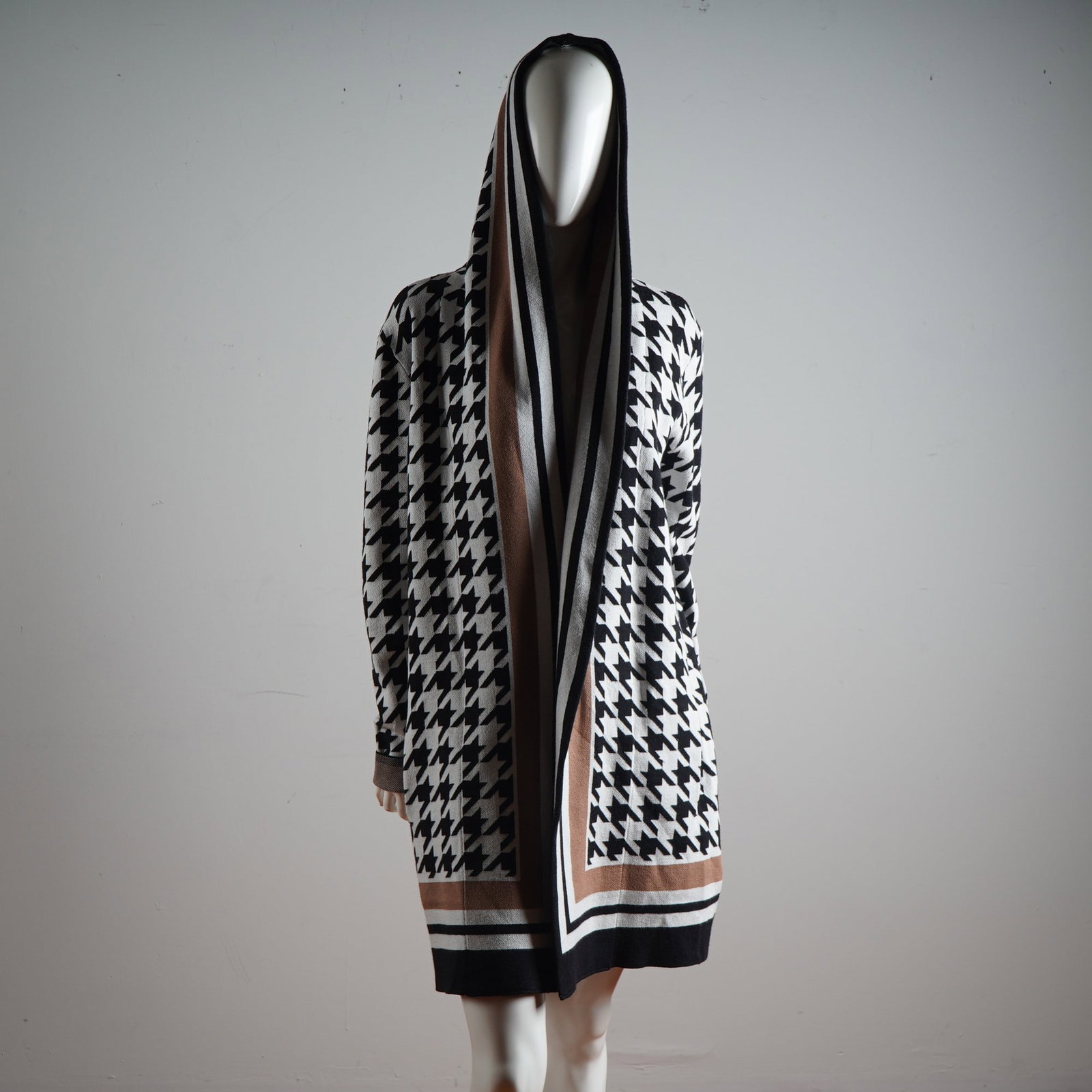 Frank Lyman Montreal Houndstooth Hooded Knit Coat: An eye-catching statement piece from the acclaimed Canadian designer Frank Lyman, this boldly patterned knit coat exudes both comfort and high fashion. Crafted in the distinctive Design Collection, th