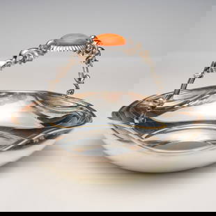 Camusso Sterling Silver Basket with Faux Orange Carnelian: Peruvian sterling silver basket crafted by Camusso, featuring a decorative arched handle with elaborate scrollwork and central bezel-set imitation orange carnelian cabochon. The shallow bowl exhibits