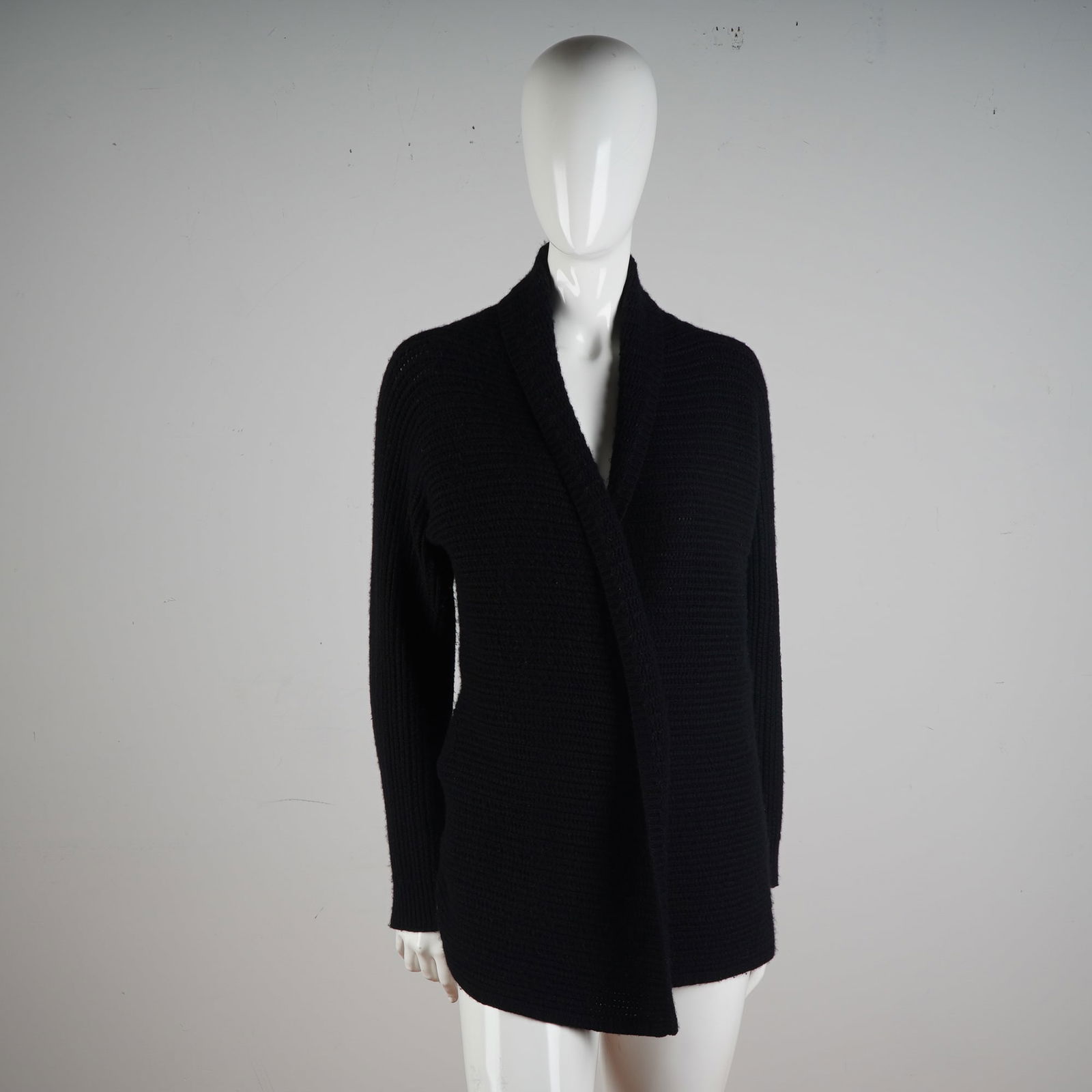 Escada Black Cashmere Knit Wrap Cardigan: A luxurious and elegant wardrobe staple, this Escada wrap cardigan is expertly crafted in Italy from pure cashmere. Rendered in a classic black hue, the design features a sophisticated rib-knit textur
