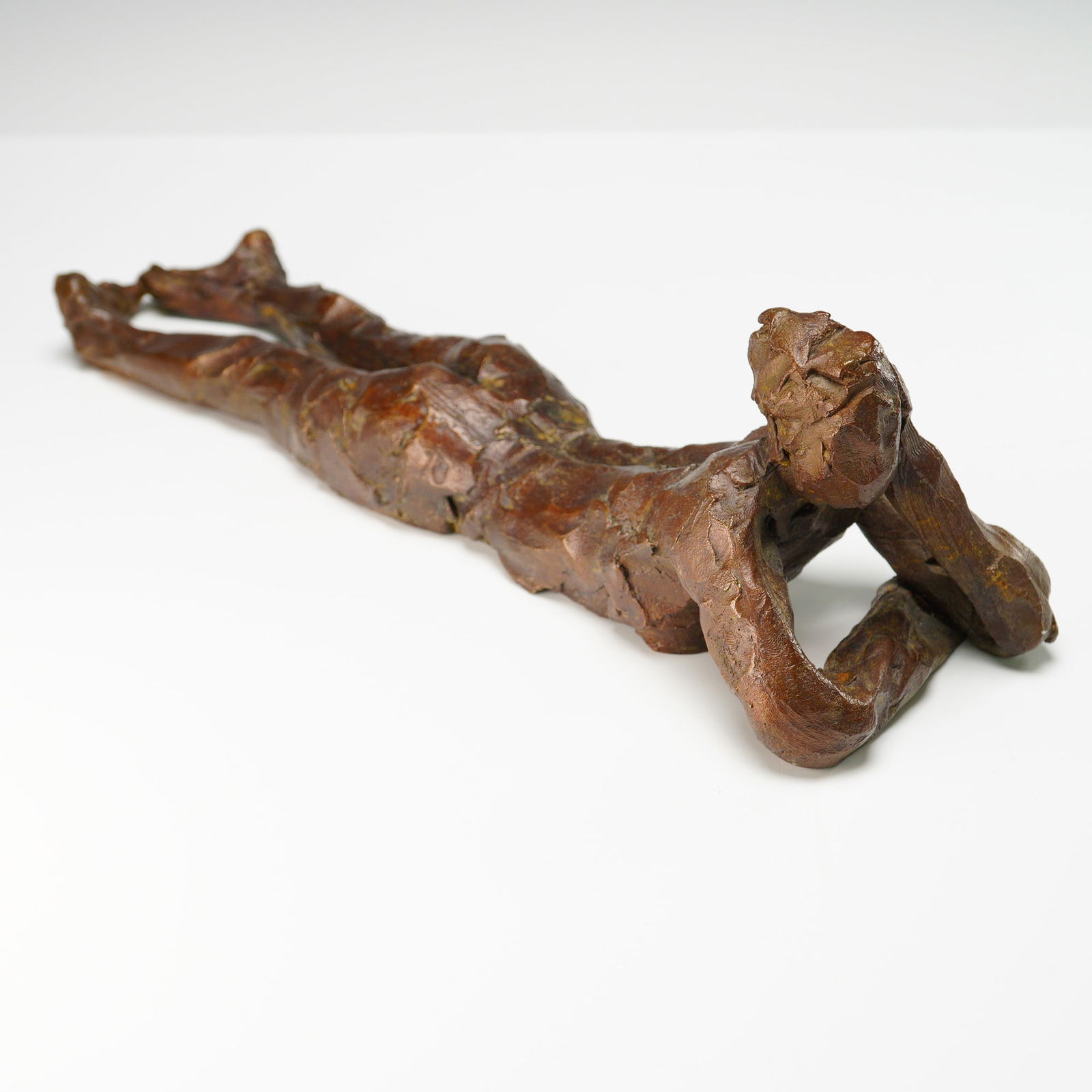 Curt Brill Bronze Figurative Sculpture, Reclining Nude with Hands Raised: This expressive bronze sculpture by Curt Brill features a reclining nude figure, elbows braced and hands tucked under the chin in a reflective pose. With Brill's signature impressionistic surface and