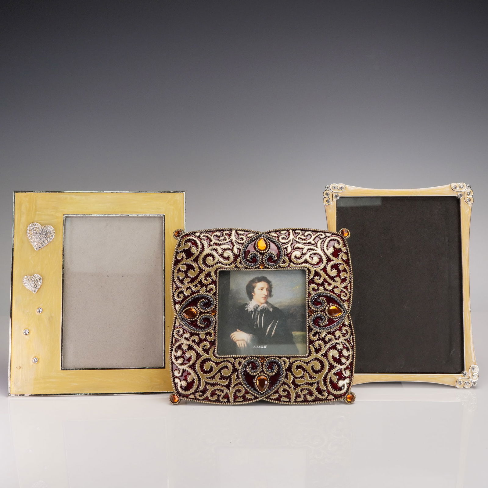 3pc Jeweled & Enamel Tabletop Picture Frames: Set of three decorative tabletop photo frames including one gold-tone rectangular frame adorned with two silver-tone pave heart appliques and clear rhinestone accents, one curved-edge frame with a gol